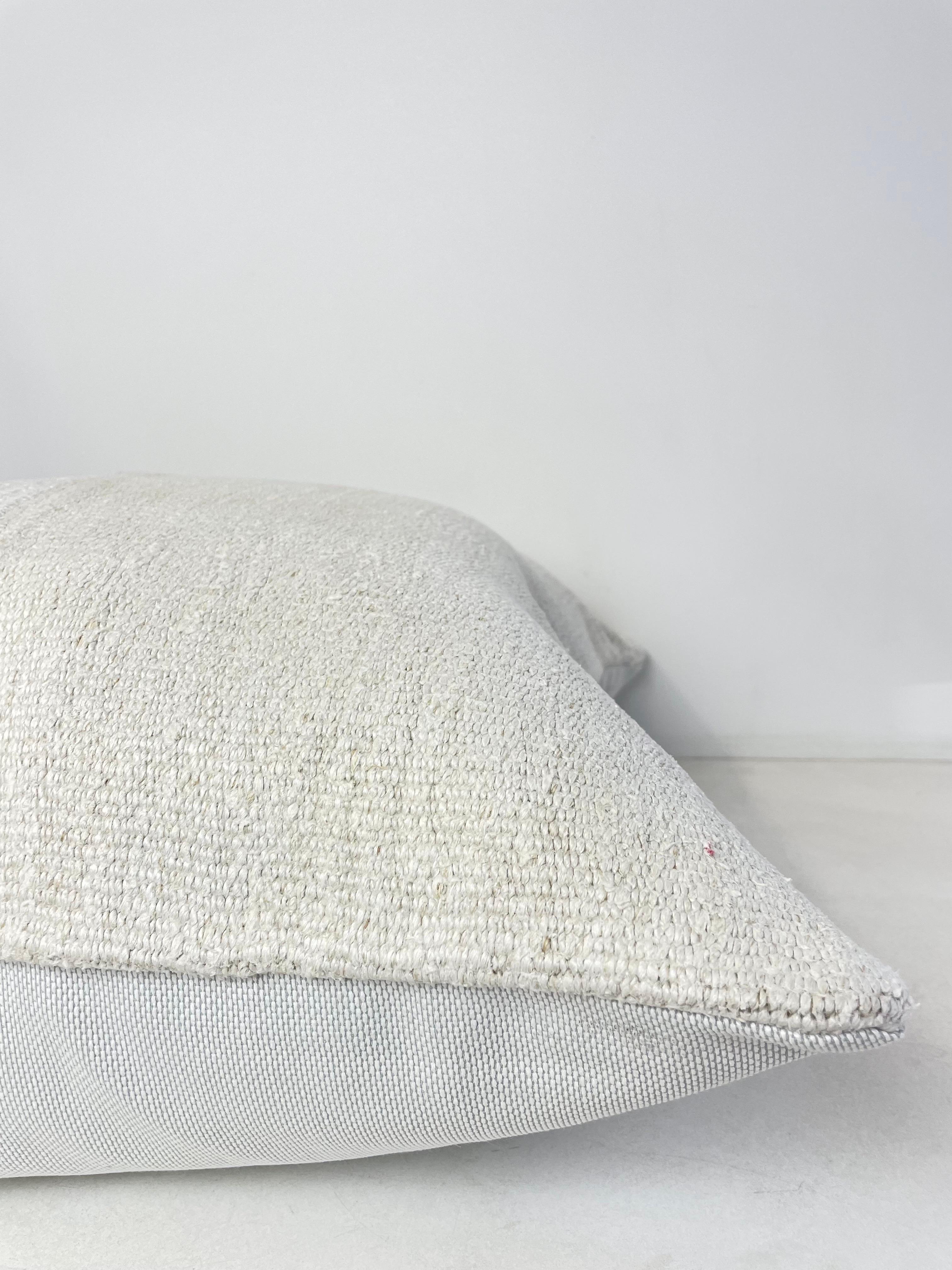 Creamy white hemp rug patchwork style pillow. Unique patchwork pillow has been made with parts of different Turkish rugs, in multiple white tones. Solid fabric backing, and hidden zipper closure. Spot cleaning is recommended, or dry clean. These