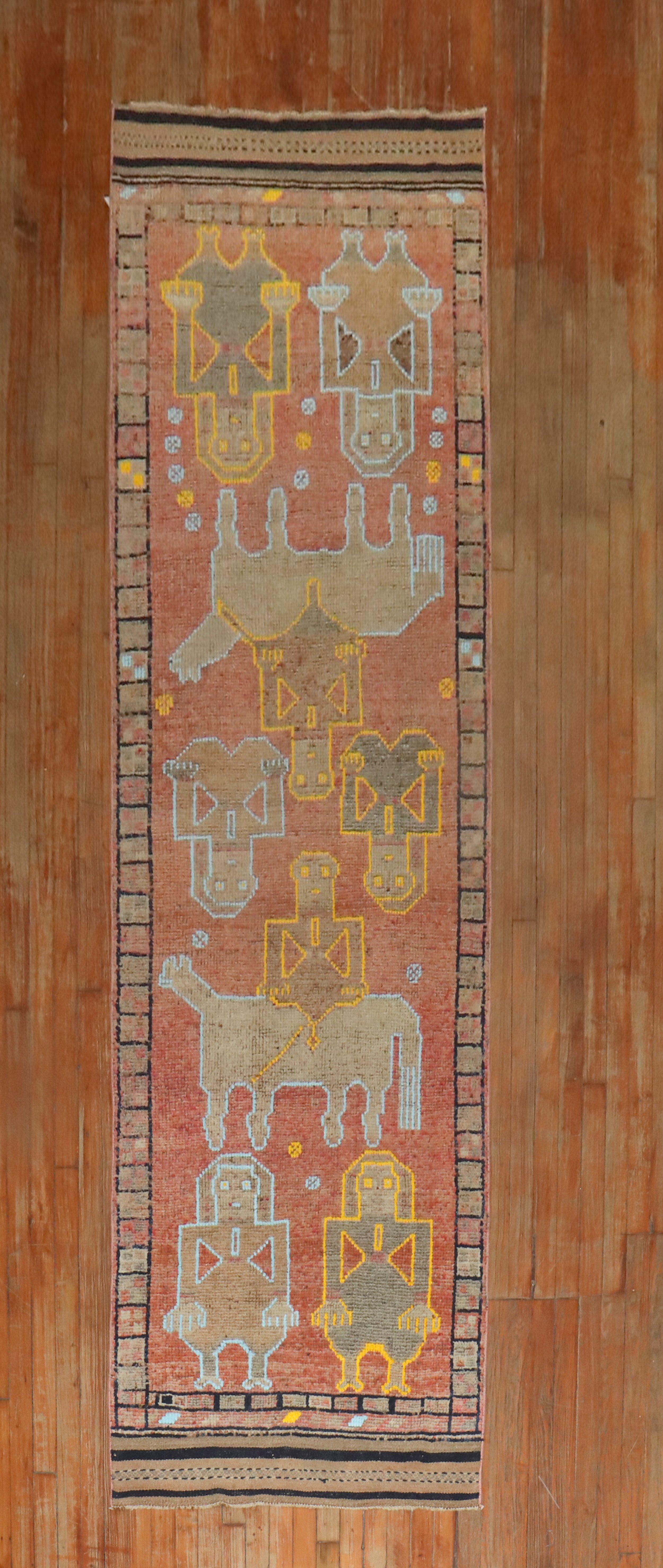 Tapis décoratif unique en son genre, coloré, datant du milieu du 20e siècle et représentant des animaux et des humains.

Mesures : 3' x 10'11''