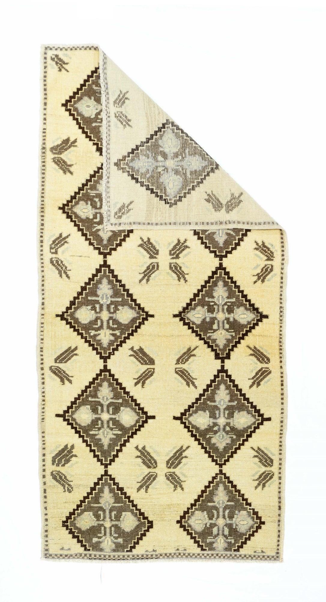 Vintage Turkish Rug 3'2'' x 6'7''. The straw field presents two columns, each of five stepped diamonds in red and brown-black, enclosing green four palmette crosses. Between are arrays of four, floating, radiating red tulips. Dotted narrow border,