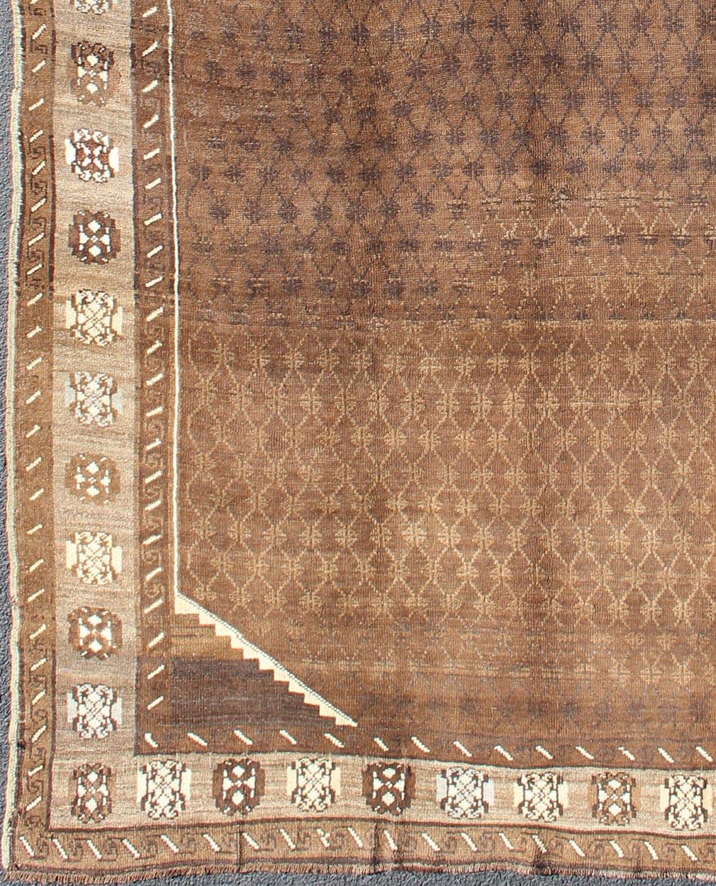 Tappeto turco vintage dal design moderno nei toni del marrone.
Questo tappeto turco vintage di grande impatto, proveniente dalle montagne della Turchia orientale, presenta una bellissima tavolozza di base in terra di Siena calda con elementi