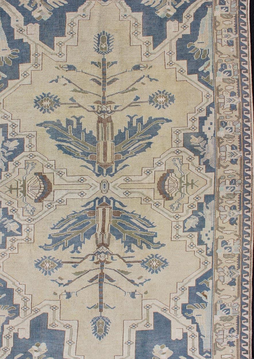 Vintage Turkish Oushak rug with central medallion in blue, faded green, brown, butter, taupe, rug TU-MTU-4851, country of origin / type: Turkey / Oushak, circa 1950

Measures: 5'7 x 9'

This enchanting and unique vintage Oushak rug , was made in