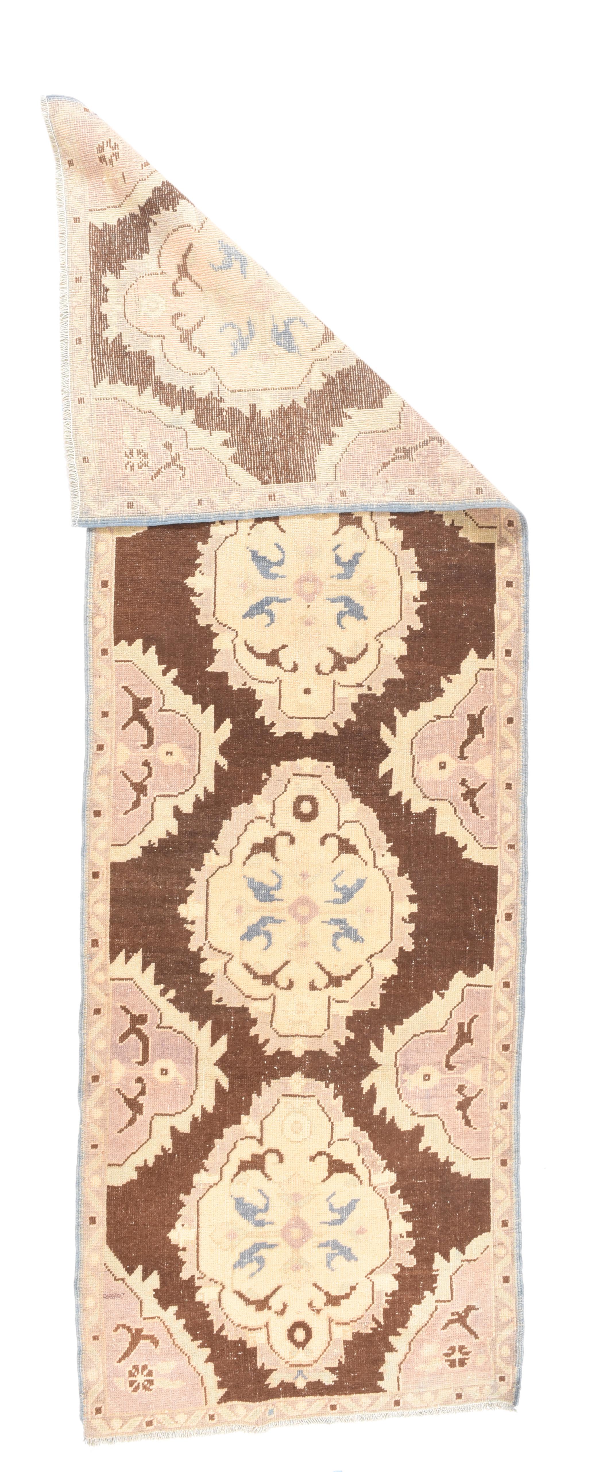 Vintage Turkish Runner 3' x 9'2''. The crimson field is decorated with four floating rough oval medallions enclosing sand cartouches, with en suite half-medallions as side fillers. Narrow border. Moderate weave. Resembles an antique Turkish velvet.