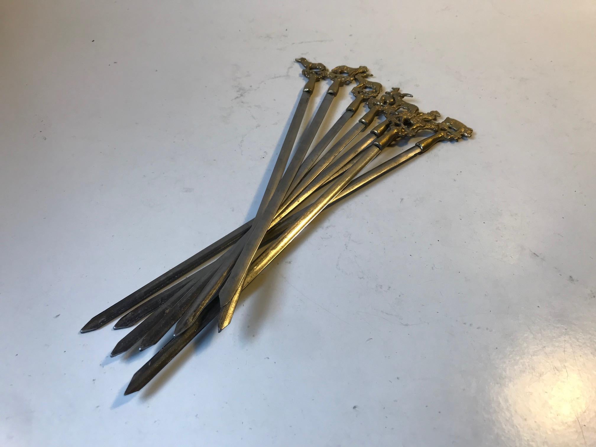 A set of 8 original Turkish sis kebab skewers. Made from practical flat stainless steel topped with handles of ornamented animals in brass. This set was manufactured by Serer in Istanbul Turkey during the 1960s or 1970s. The length of the Skewers is