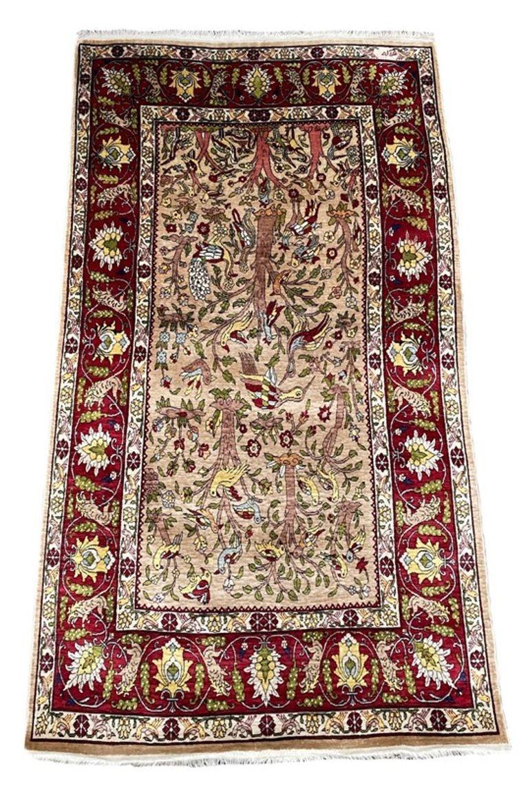 Un eccezionale tappeto turco in seta, tessuto a mano a Hereke (circa 60 km a sud-est di Istanbul) nel 1980 circa, con un disegno dell'Albero della Vita all over su un morbido campo beige e favolosi colori secondari di rosso, verde e oro. Tessuto