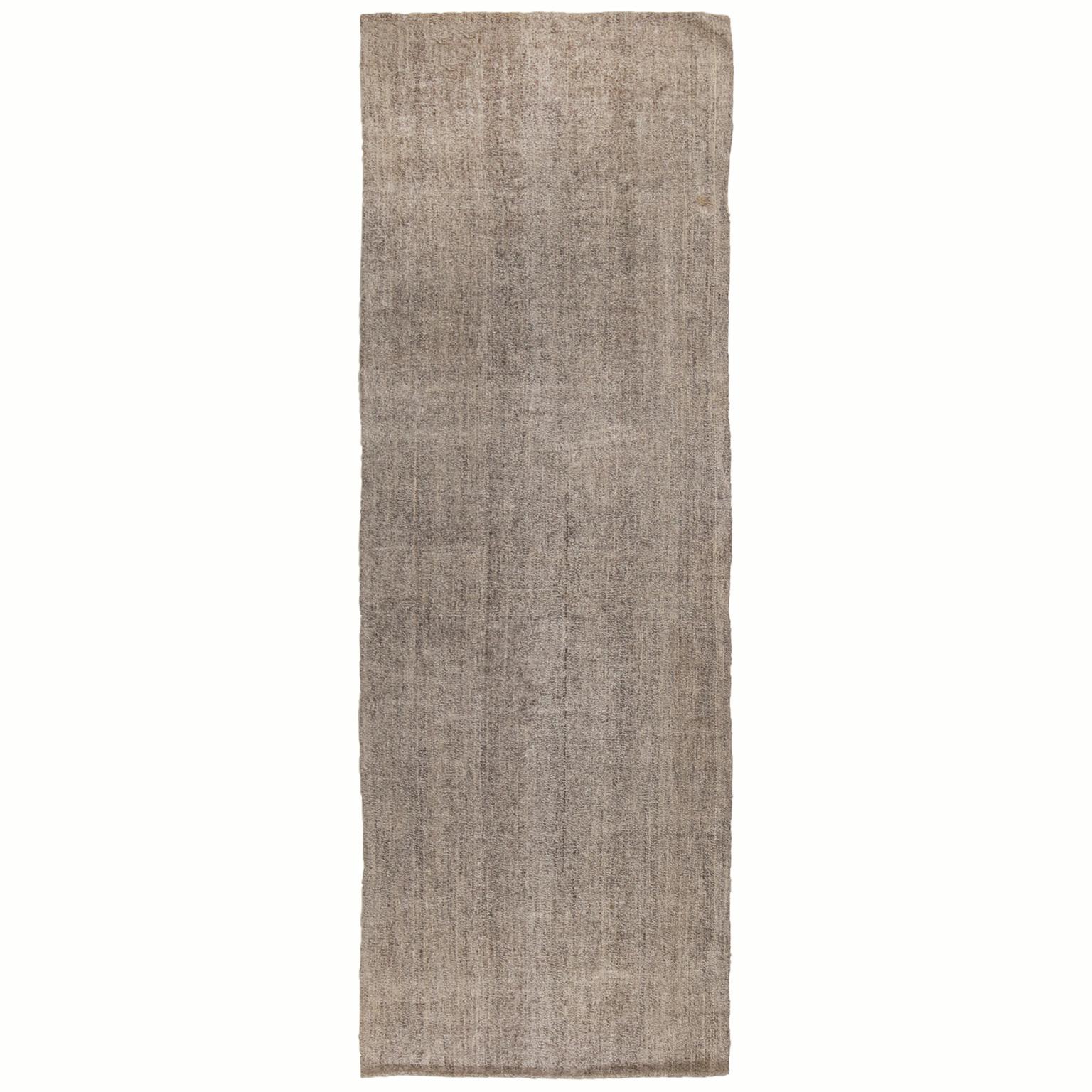 Originating from Turkey in 1960, this vintage wool Kilim runner is flat-woven in high quality wool with subtly rectilinear, vertically oriented abrash of Industrial and metallic gray and silver colorways.
   
