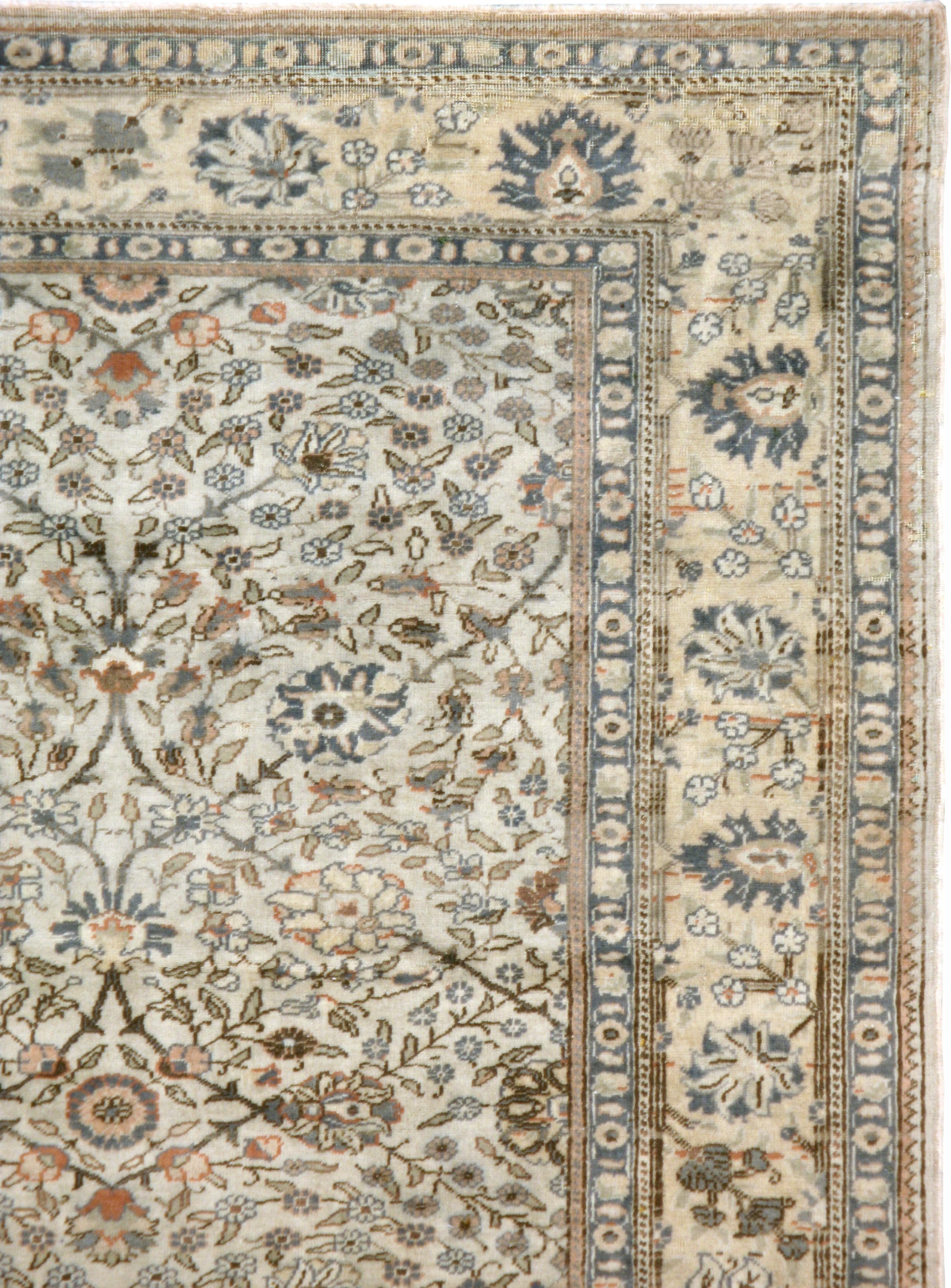 A vintage Turkish Sivas carpet from the mid-20th century. Thin vines and swirls of tiny leaves are the main ornamentations of the ivory ground of this eastern Turkish town rug. The straw yellow main border mixes erect and tilted palmettes with