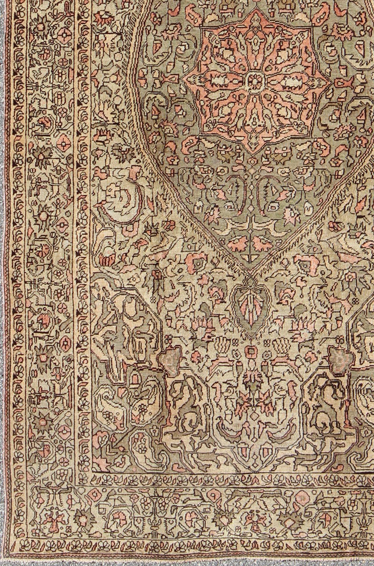 Measures: 5'6 x 9'11

This Turkish Sivas showcases a floral design utilizing botanical motifs spread through the central medallion, continuing across to the wide banded border and border guards. The earthy palette consists of sandy beiges, taupe,