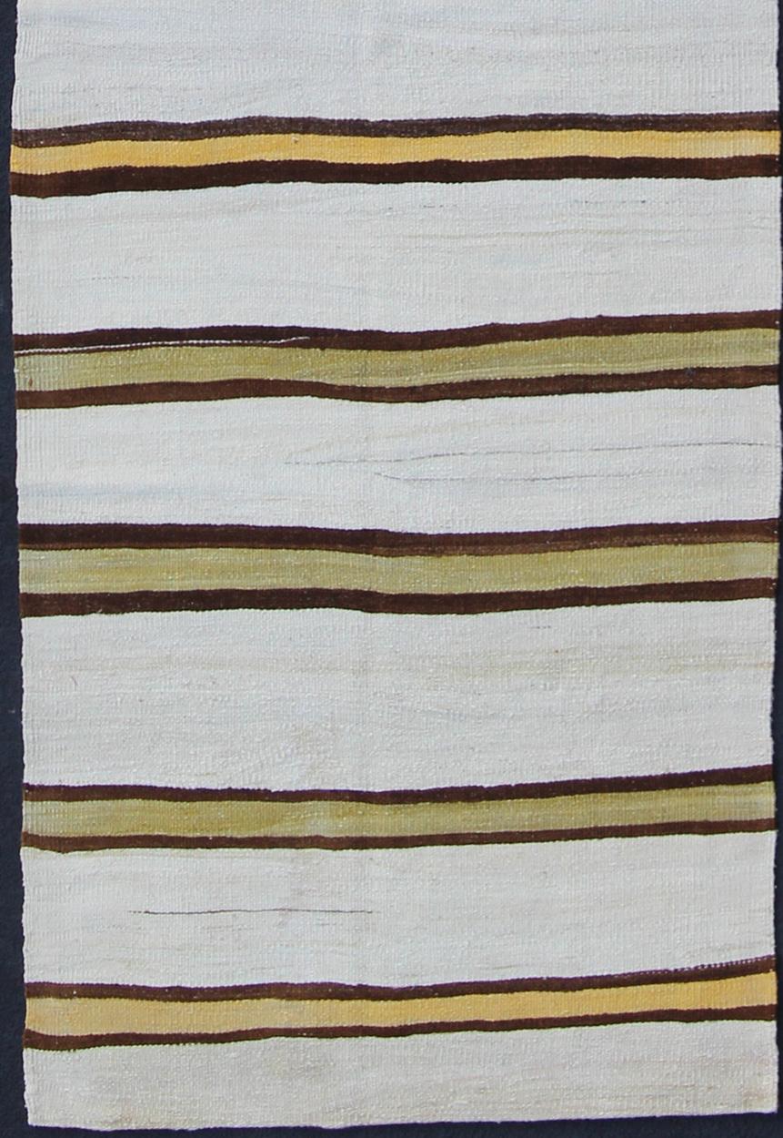 Green, yellow, ivory, and onyx-colored Kilim runner from Turkey with Minimalist stripe design, rug en-165310, country of origin / type: Turkey / Kilim, circa 1950.

Featuring a striking stripe design, this unique 1950s Kilim runner showcases