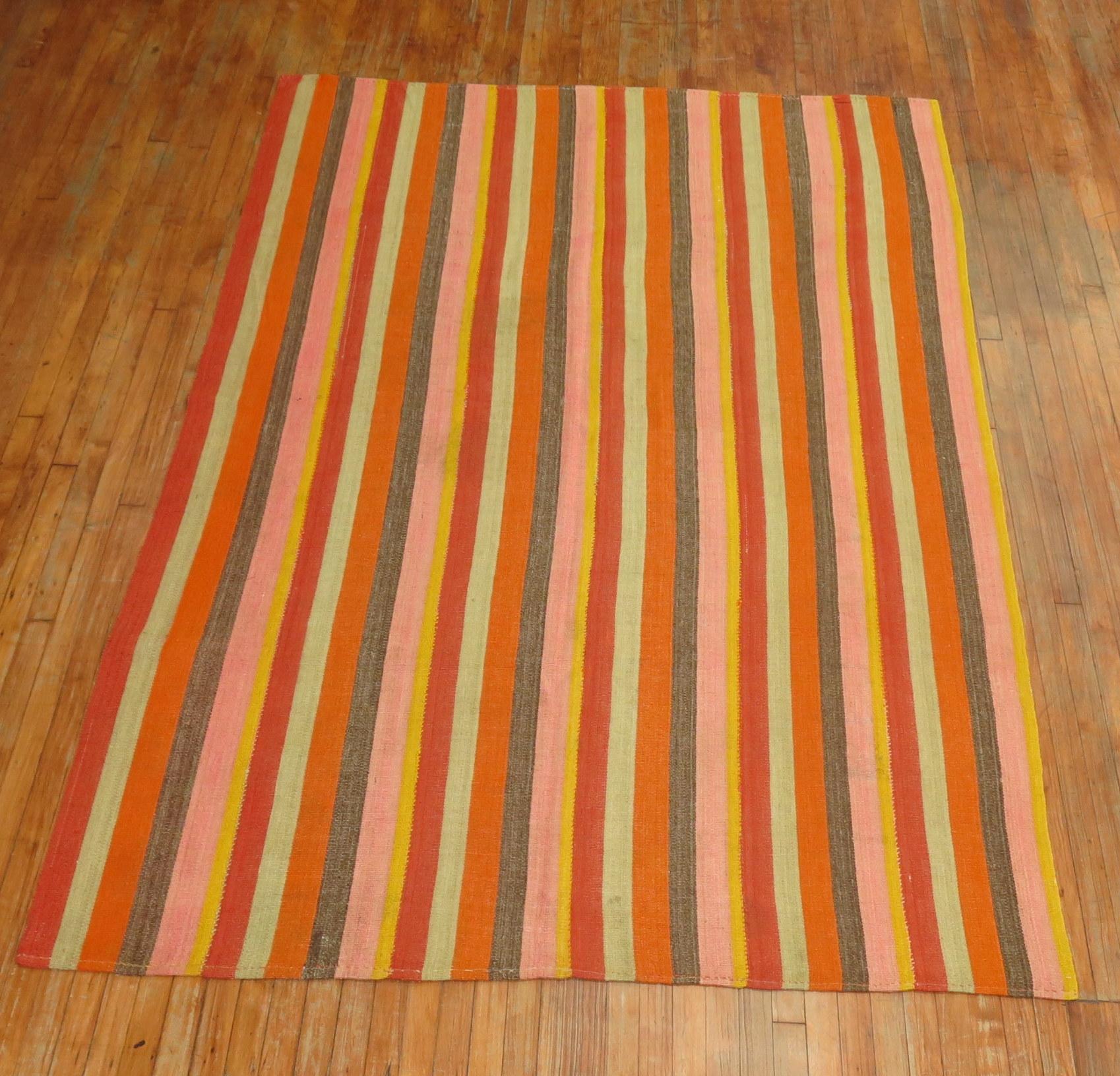 20th century Turkish Kilim with a striped motif in orange, pinks, reds, yellows, teal and brown.