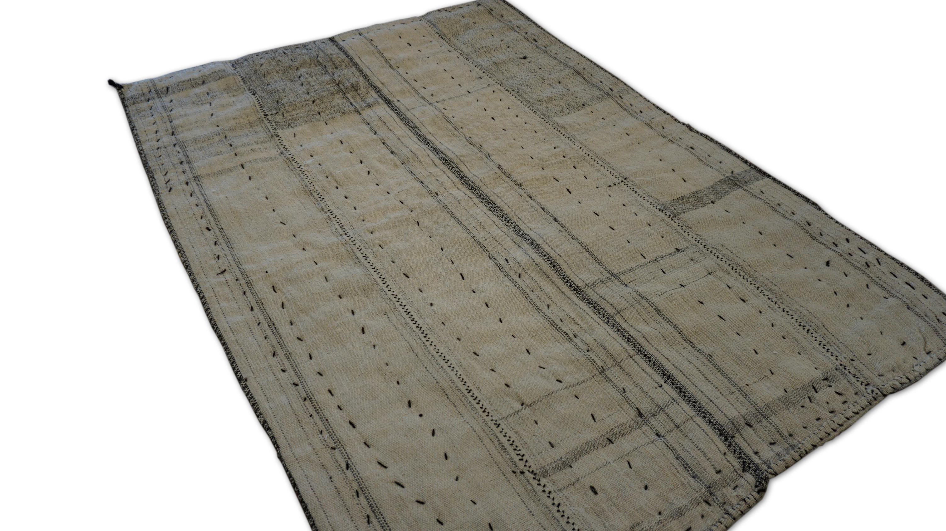 This vintage Turkish tribal blanket rug is a beautiful example of flatwoven utility textiles from Anatolia, originally woven for use as bedding or covers in nomadic households. Crafted in soft, hand-spun wool, the piece features an understated ivory