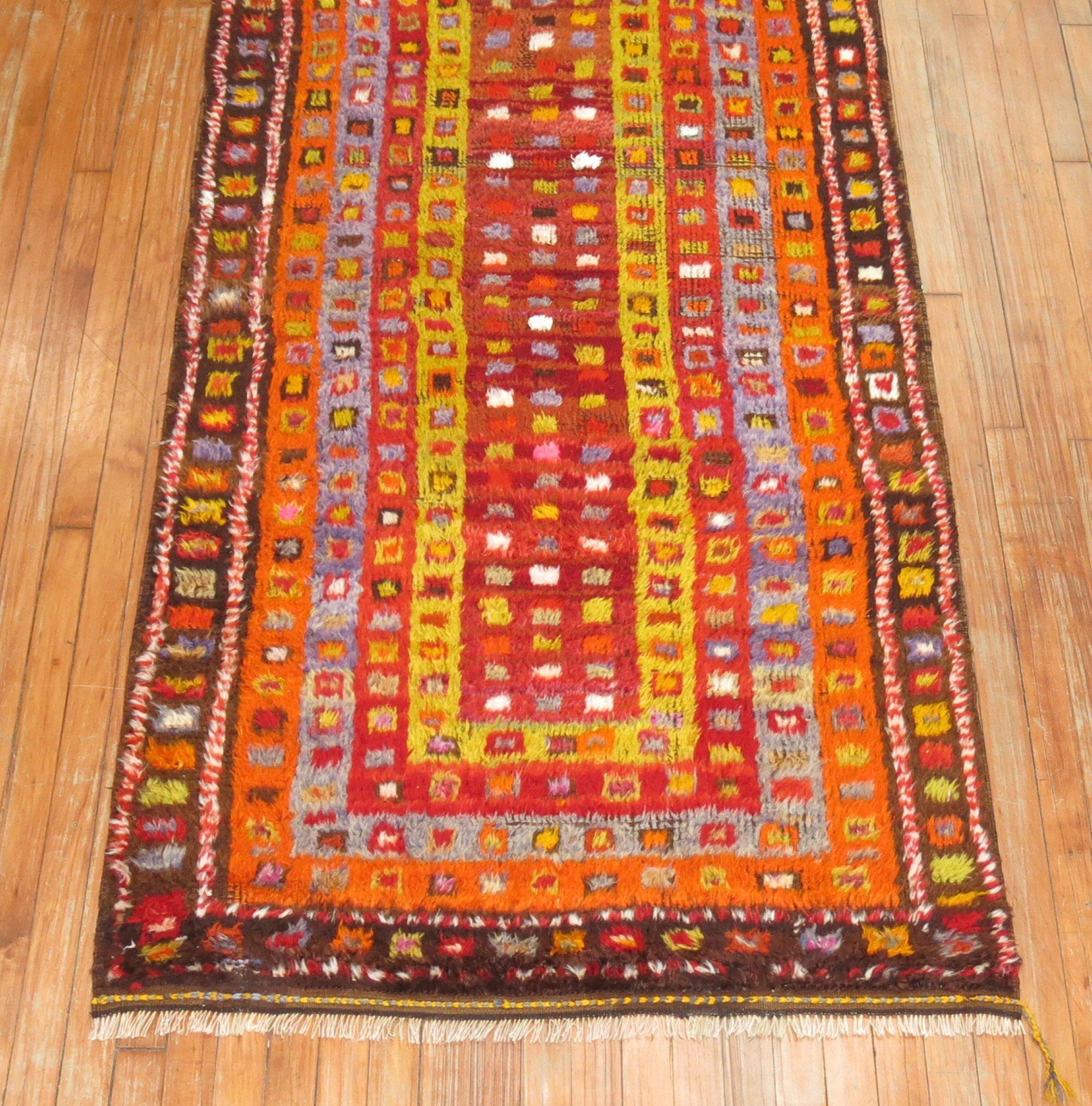 Bright colors highlight this mid-20th century vintage Turkish Tulu rug.