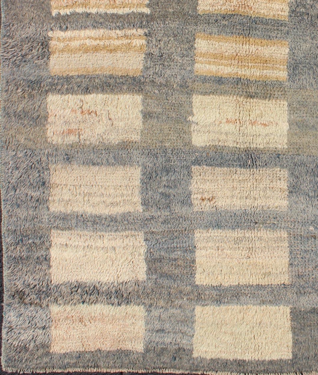 This Tulu carpet features sand colored rectangular shapes with gray outlines. Tulus are woven in the Konya area with a coarser weave. The wool used in these rugs is exceptionally durable, and they are always visually polished.

Measures: 3'6'' x