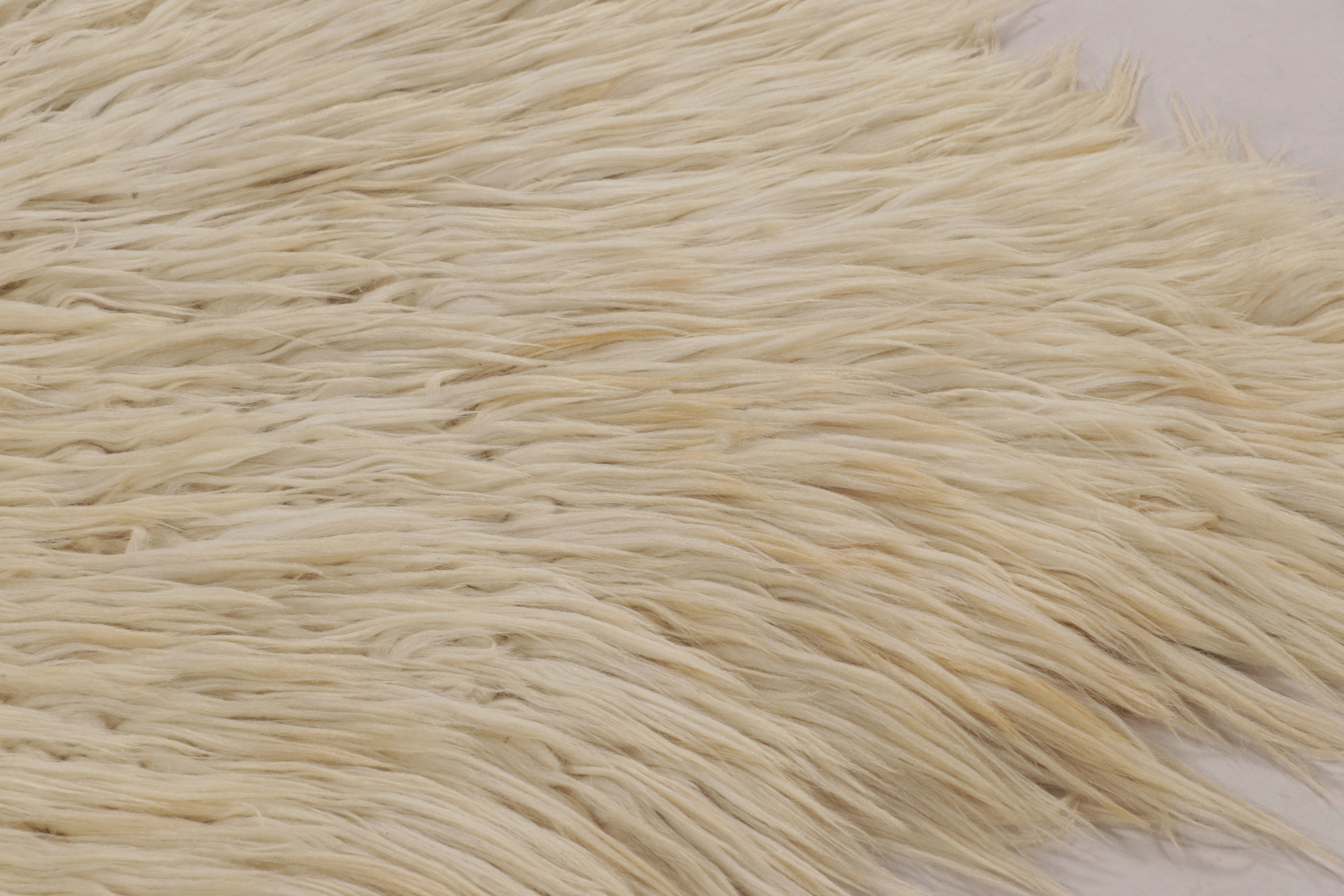 Fabriqué en Turquie avec de la laine nouée à la main, ce tapis Tulu vintage de 5x7 est un ajout distingué à la collection de textiles turcs traditionnels de Rug & Kilim. Sa surface beige douce et solide et sa texture pelucheuse en font un objet de