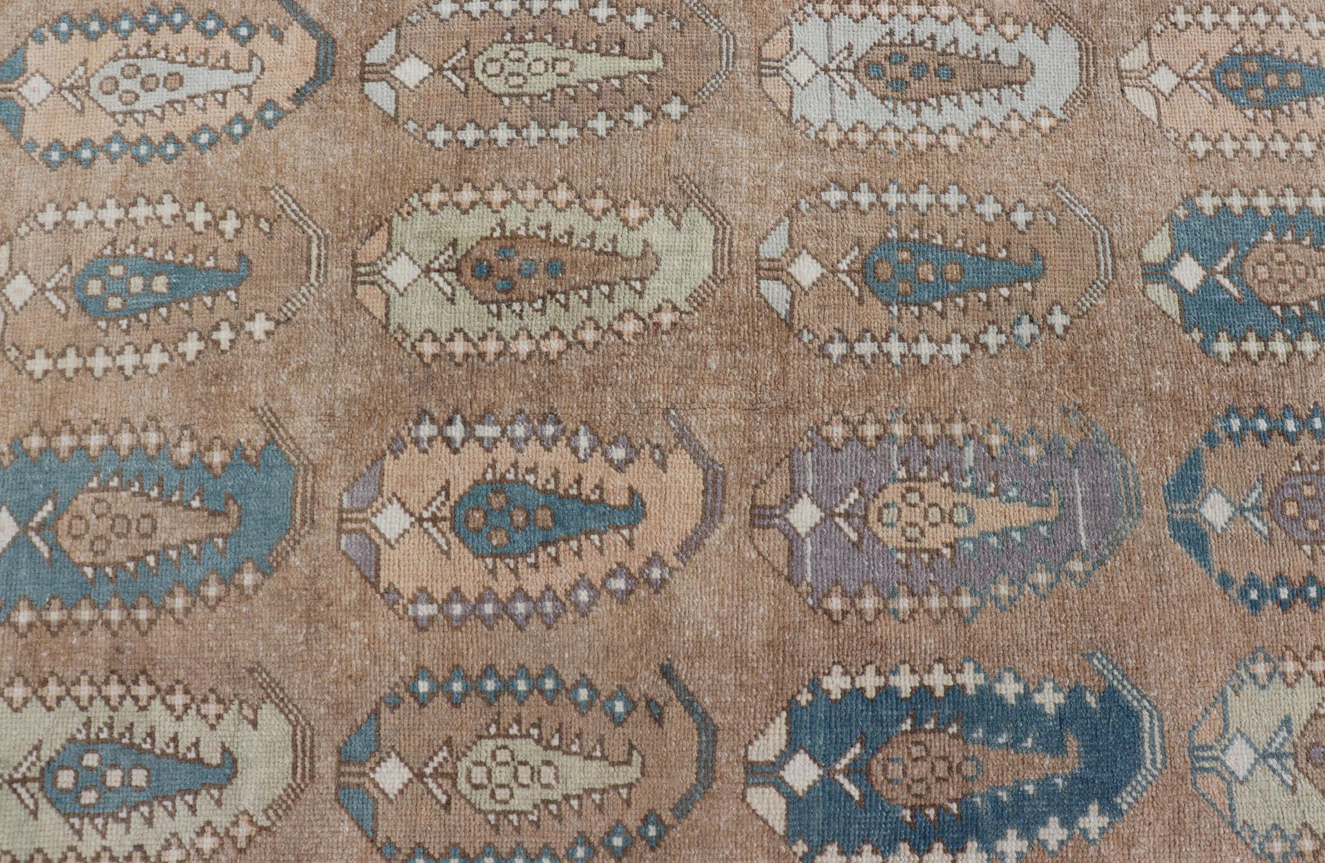 Misure: 3'5 x 6'1.
Questo affascinante tappeto vintage turco Tulu presenta un motivo unico di medaglioni paisley, ognuno dei quali è ricco di intricati motivi geometrici. La base del tappeto è caratterizzata da morbide tonalità della terra, tra cui