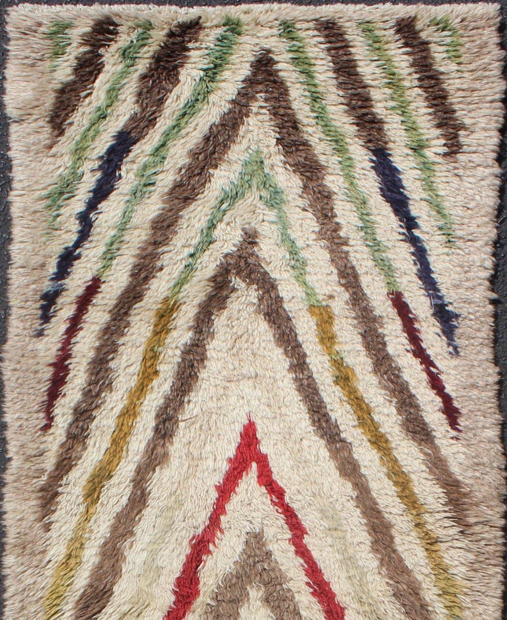 This Tulu runner contains a repeating arrow design laid across an off white field. Tulu rugs are woven in the Konya area with a very coarse weave and pile to accentuate the tribal pattern. The wool used in these rugs is exceptionally fine and