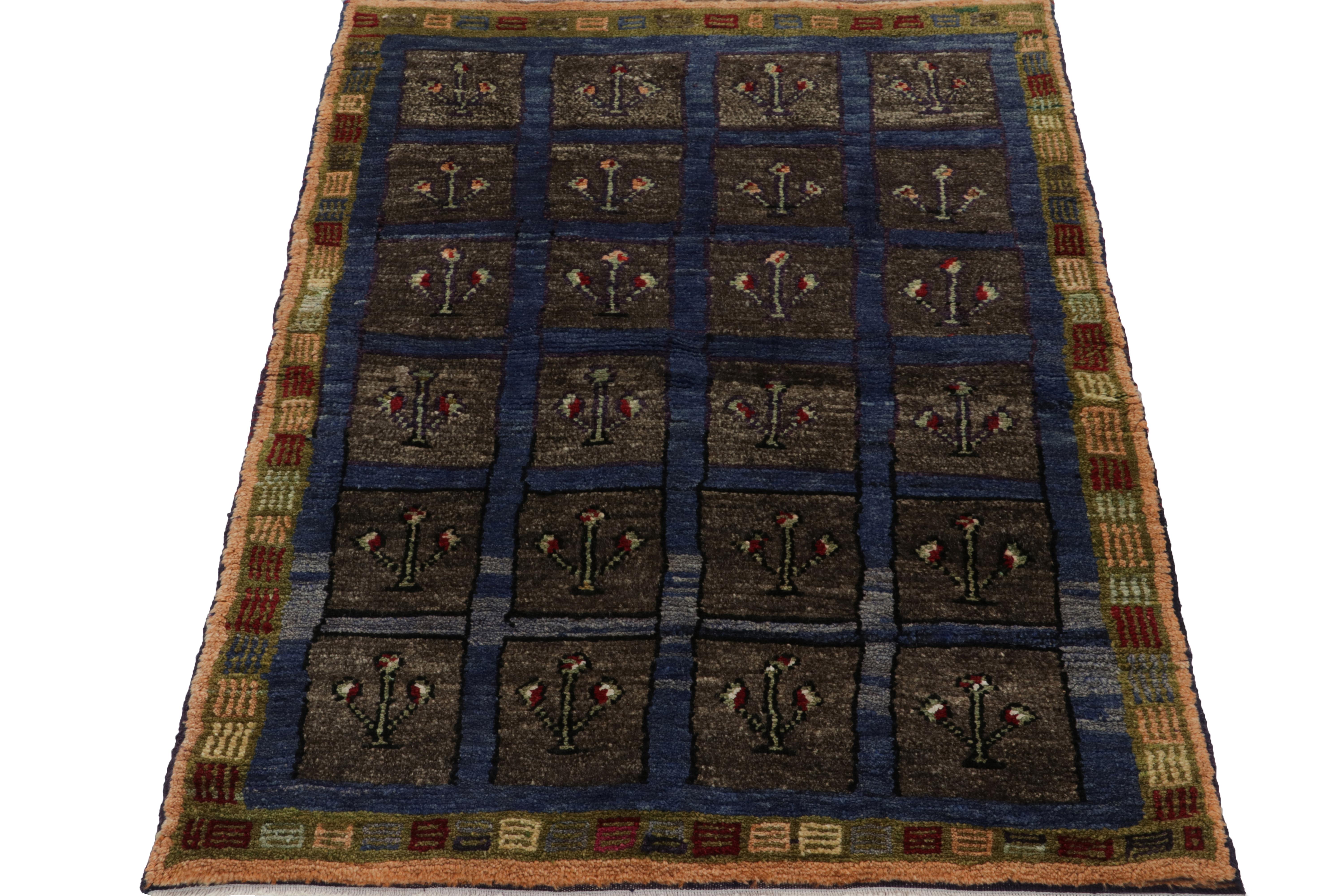 Coming from Turkey circa 1950-1960, a 3x4 vintage Tulu rug featuring tribal geometric patterns in deep blue & dark grey - seemingly forming compartments to envelope flower buds. Handwoven in wool, the vision relishes a softer color variation on the