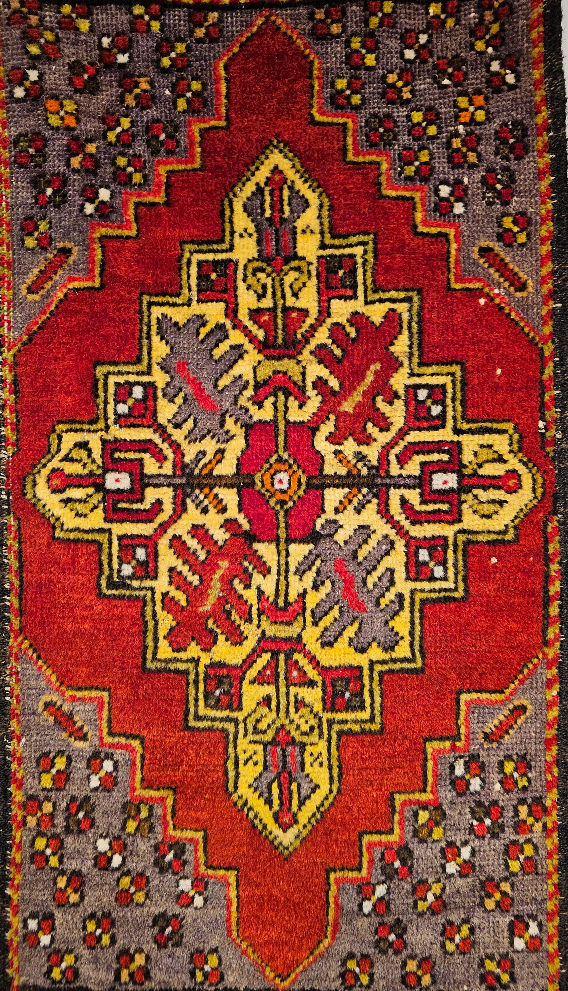  A beautiful Anatolian village rug in a prayer rug design in vibrant colors including yellow, red, purple from the mid 1900s .  The rug has a central medallion in a wonderful yellow color with designs in red set on a bright red background.  The