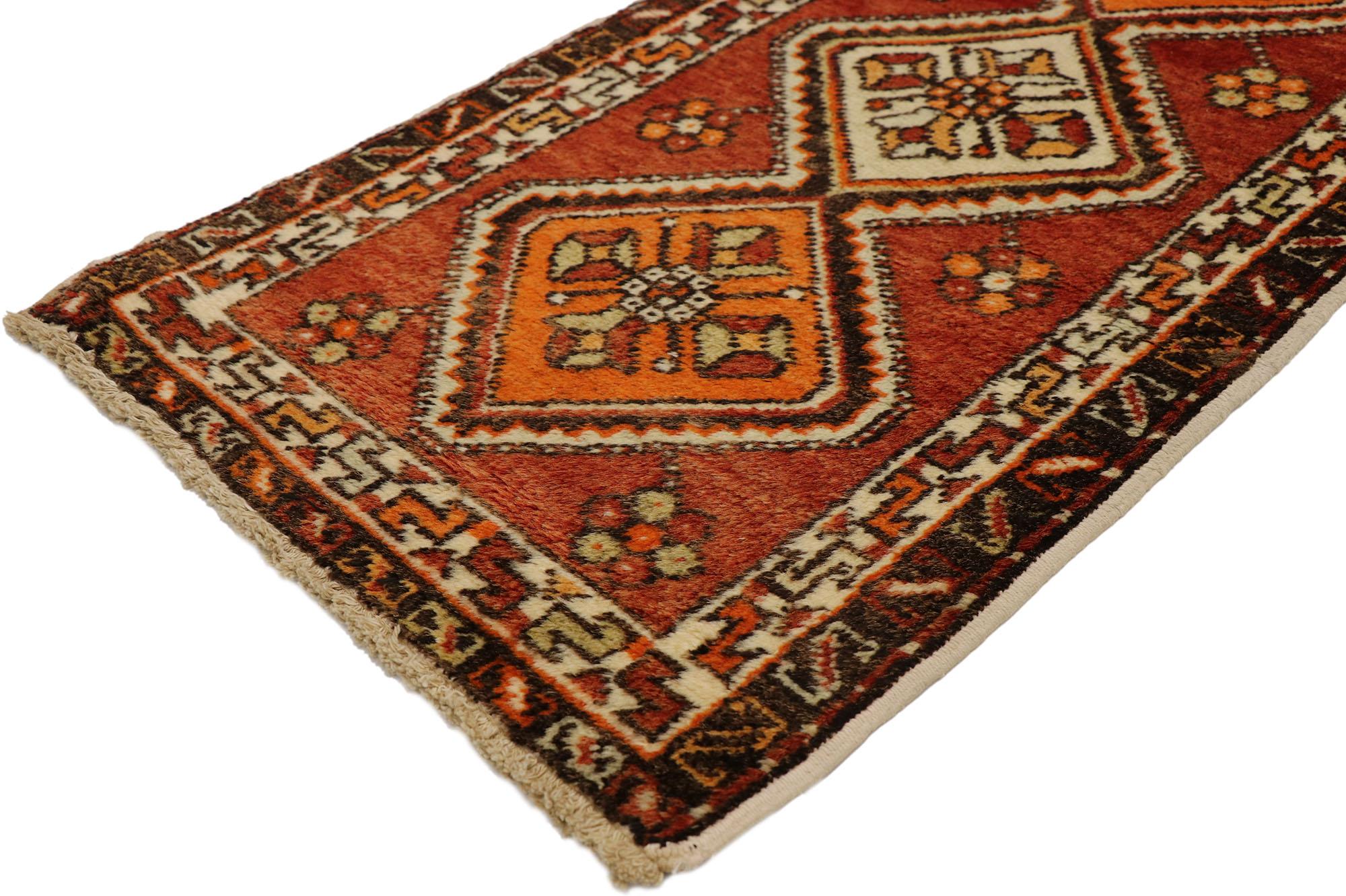 50951 Tappeto Vintage Yastik, 01'08 x 03'02. Immergiti nel fascino vibrante di questo tappeto vintage turco Yastik in lana annodato a mano, una vera e propria testimonianza dell'arte e della maestria dei tessitori turchi. Il ricco campo rosso fuoco