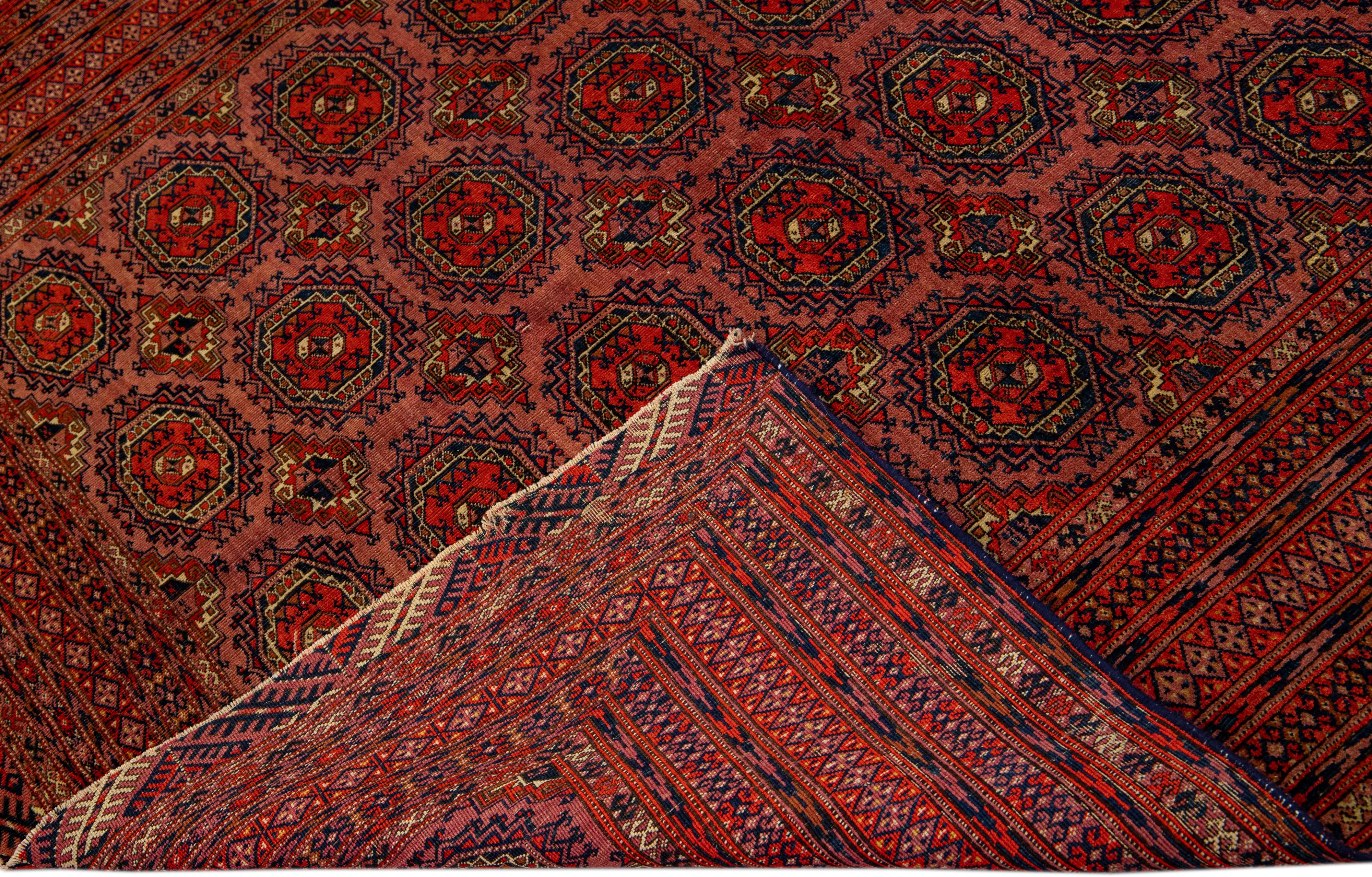 Beautiful vintage Turkmen hand-knotted wool rug with a terracotta field. This Persian rug has navy blue and red accents in a gorgeous all-over geometric Pattern Design.

This rug measures: 5'6