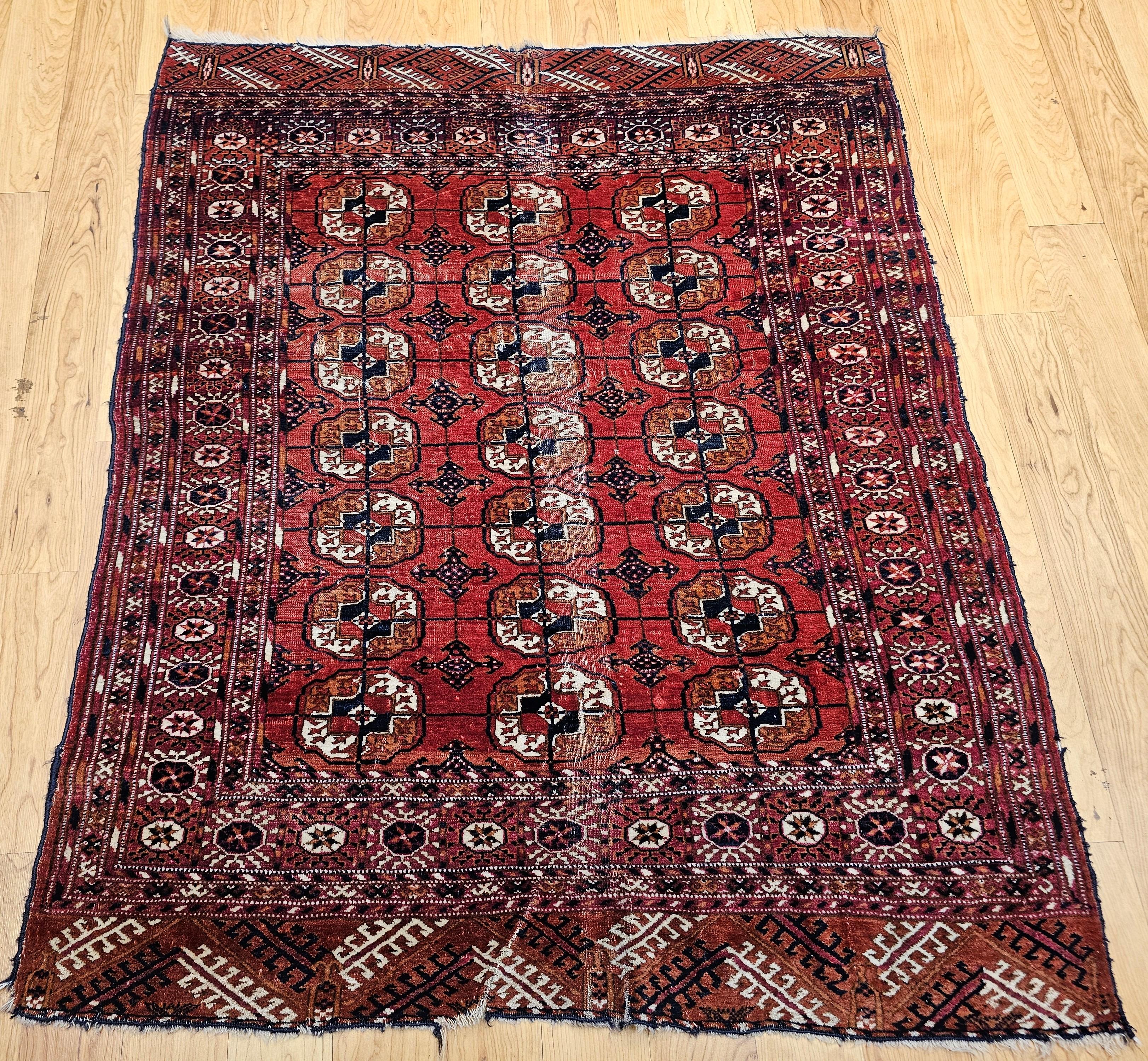  Un raffinato tappeto vintage Tekke dei primi anni del 1900, con un dettagliato disegno geometrico a medaglione. Annodato a mano con precisione, questo pezzo tribale presenta un caldo campo rosso mattone con gul ripetuti in scala ridotta nei toni