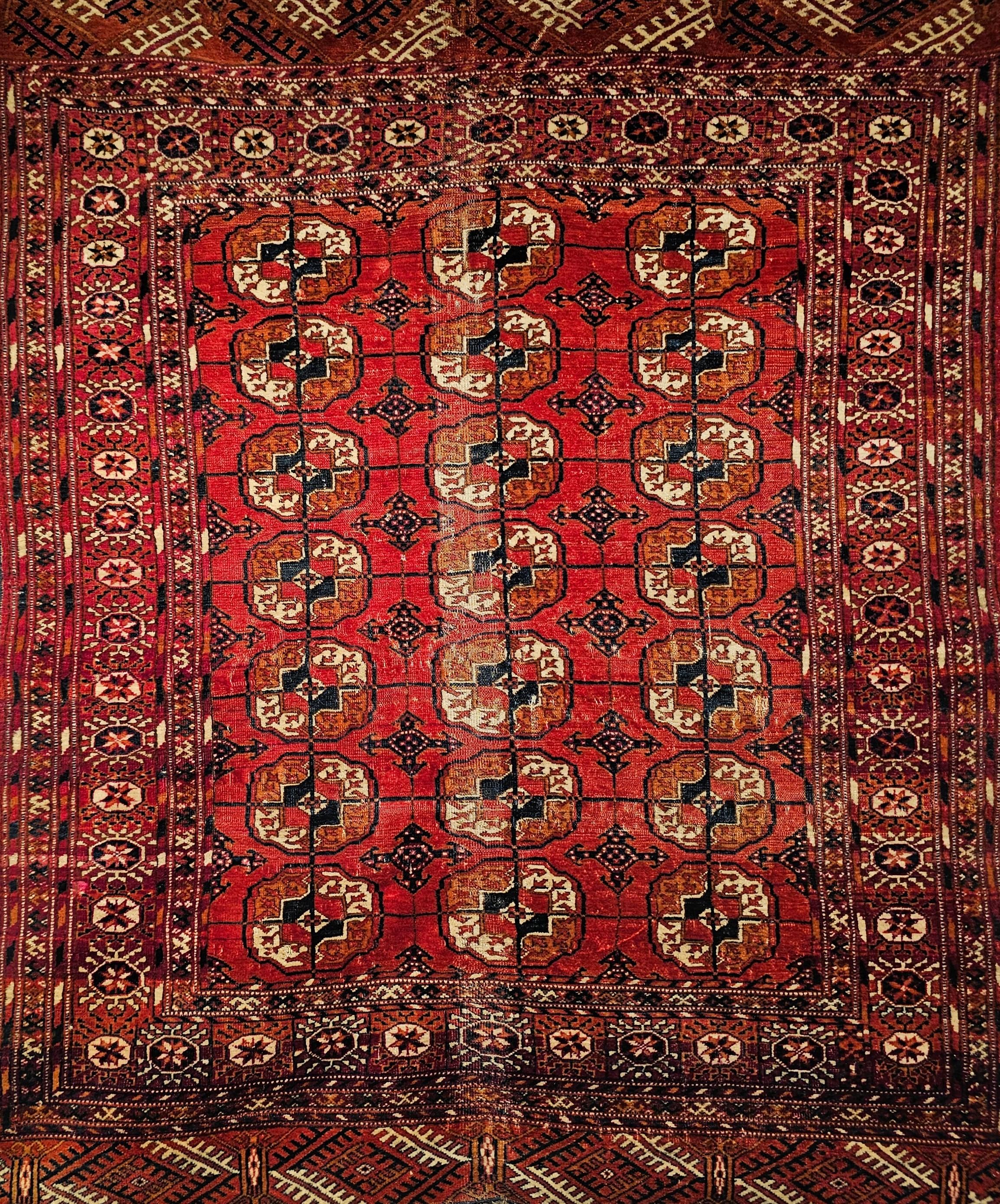 Alfombra Turkmen Tekke Vintage con diseño integral en rojo ladrillo, azul marino y marfil