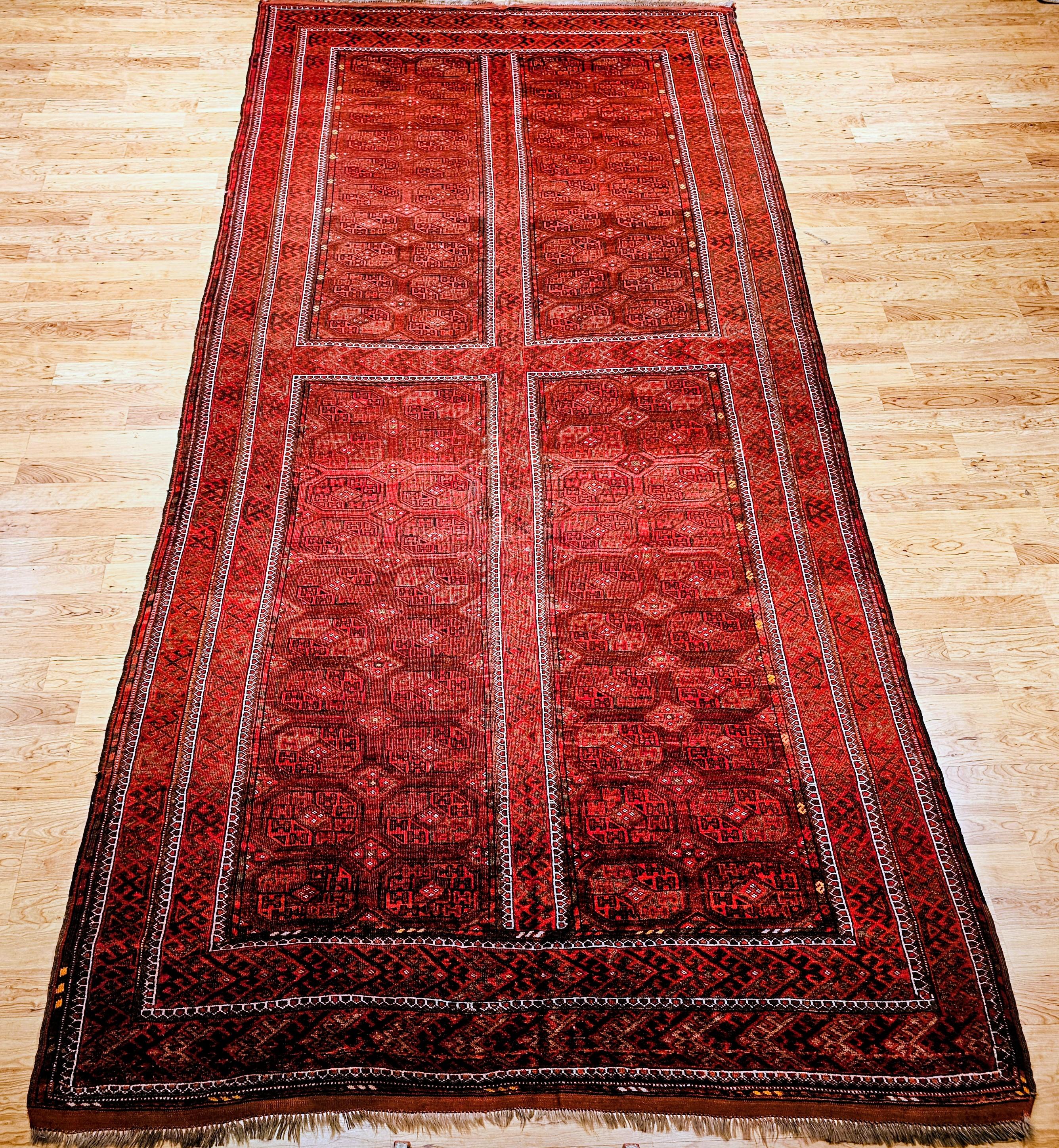 Tapis de galerie ou de couloir vintage Tekke à motif géométrique en médaillon (Turkmen Gul) en rouge brique avec des accents de vert, de marron et de gris.    Le tapis noué à la main Tekke du Turkménistan a été tissé avec de la laine filée à la main