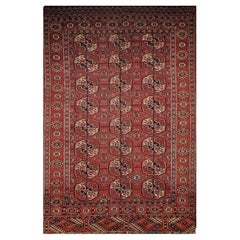 Alfombra Turkmen Tekke Vintage con diseño geométrico en rojo ladrillo, azul marino y rosa