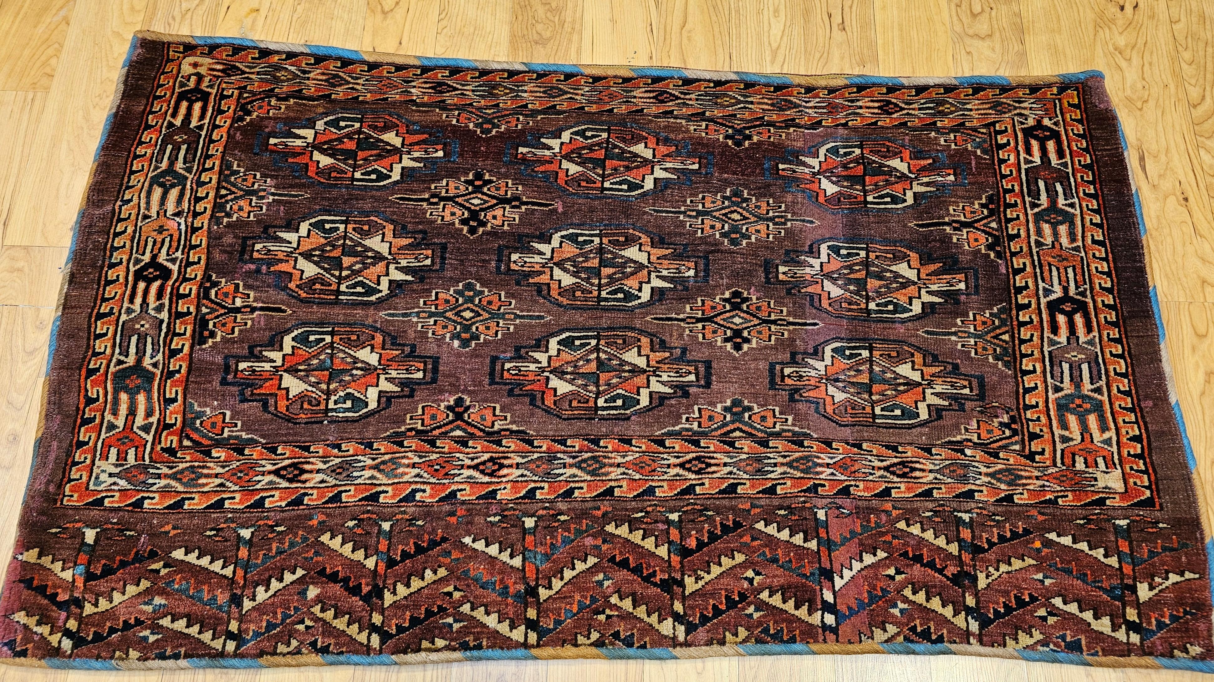 Diese exquisite antike Yomut-Tschowal-Tasche aus den frühen 1900er Jahren zeigt die zeitlose Kunst der turkmenischen Weberei. Die Vorderseite zeigt das ikonische 3×3 turkmenische Gul-Muster (Medaillon oder Blume), das meisterhaft in tiefem Rot,