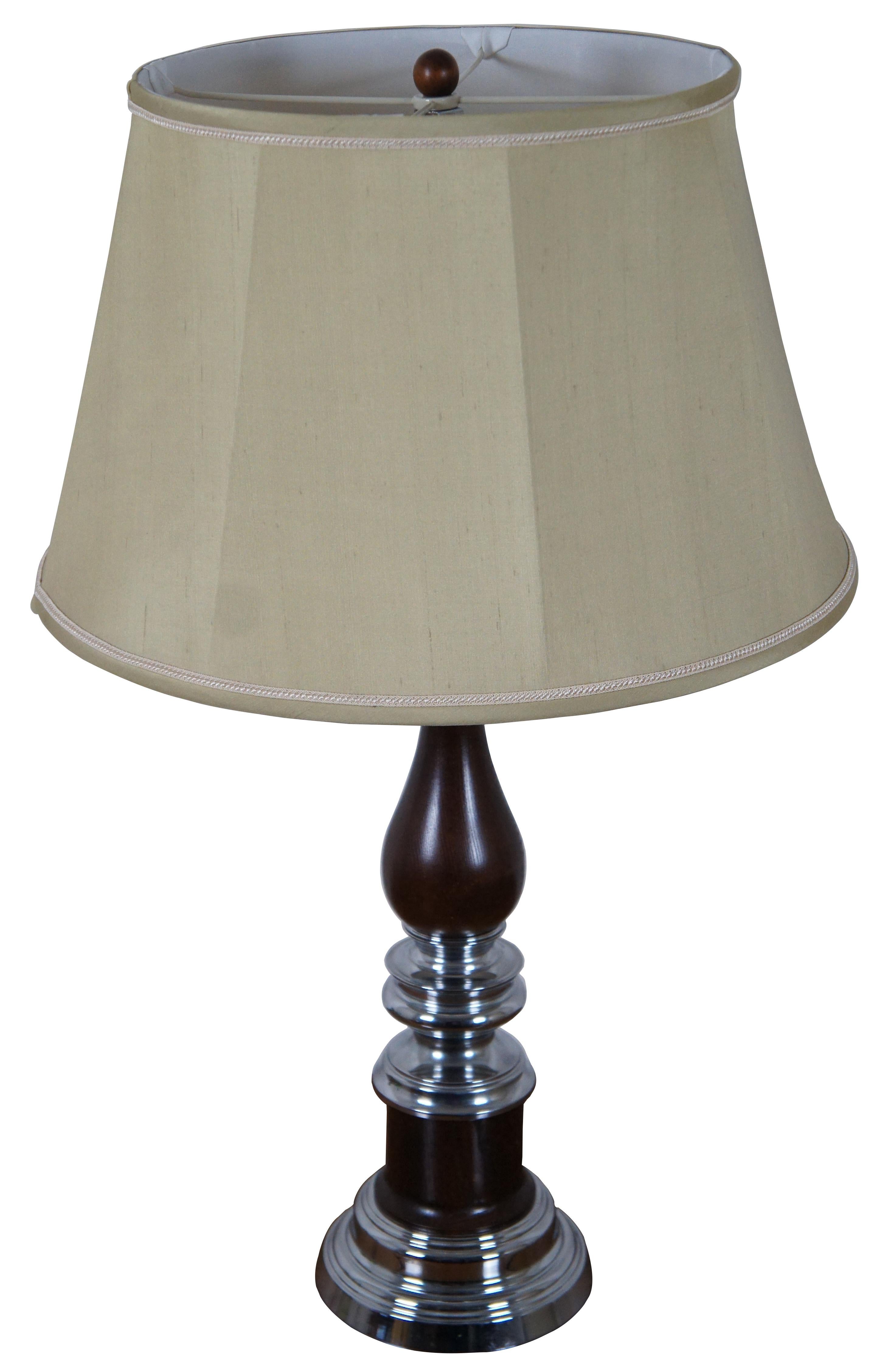 Vintage trophy form turned oak (wood) and chrome table lamp with light olive green shade.

Measures: 7.25” x 24.75” / Shade - 19” x 11.75” / Total Height – 31” (Diameter x Height).