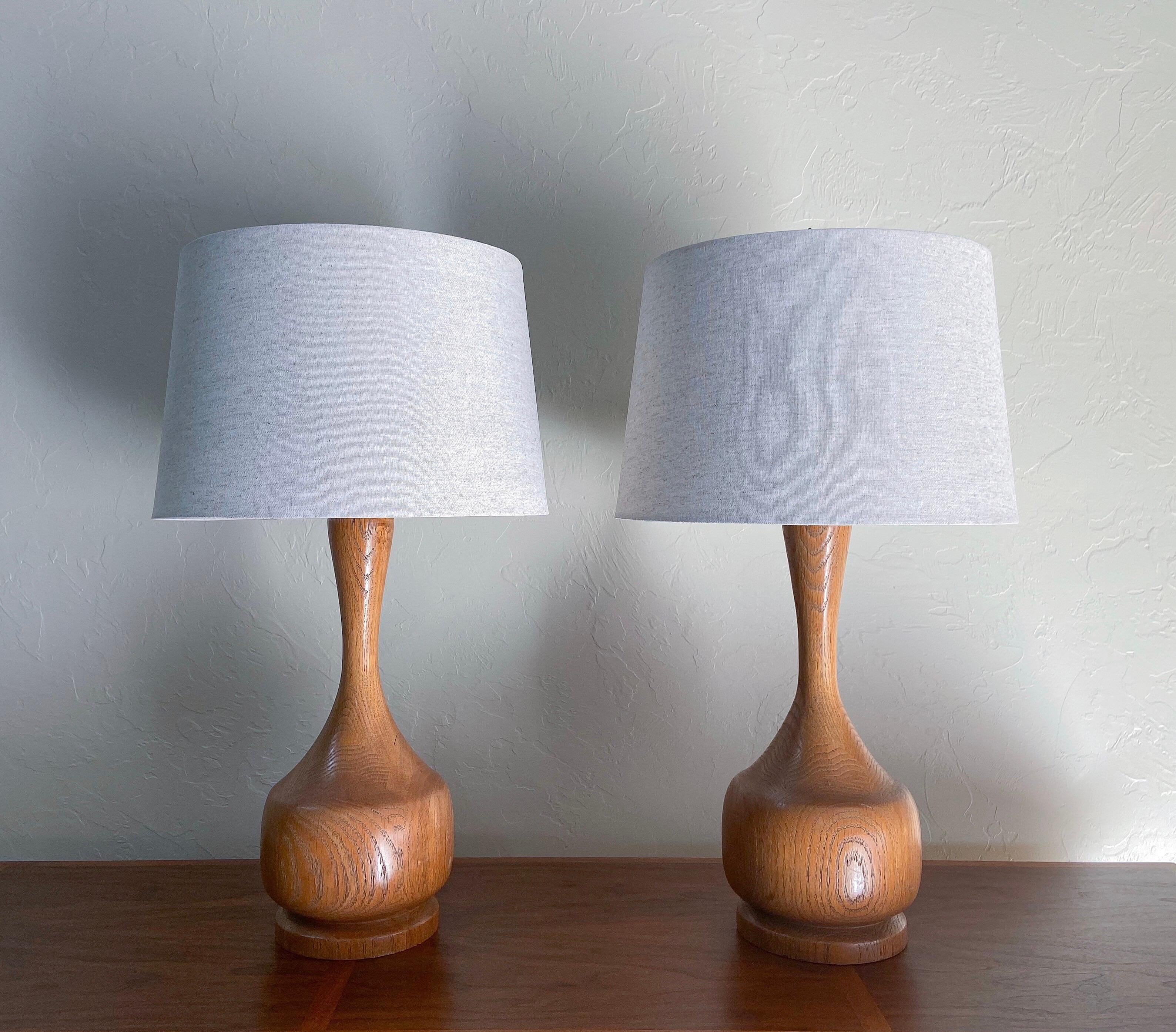 A wonderful one of a kind pair of lathe turned table lamps circa 1970. 

These are very well executed. Made from solid oak and featuring a lovely organic form. Oak has a natural warmth 

These will be a great addition to any Mid-Century Modern,