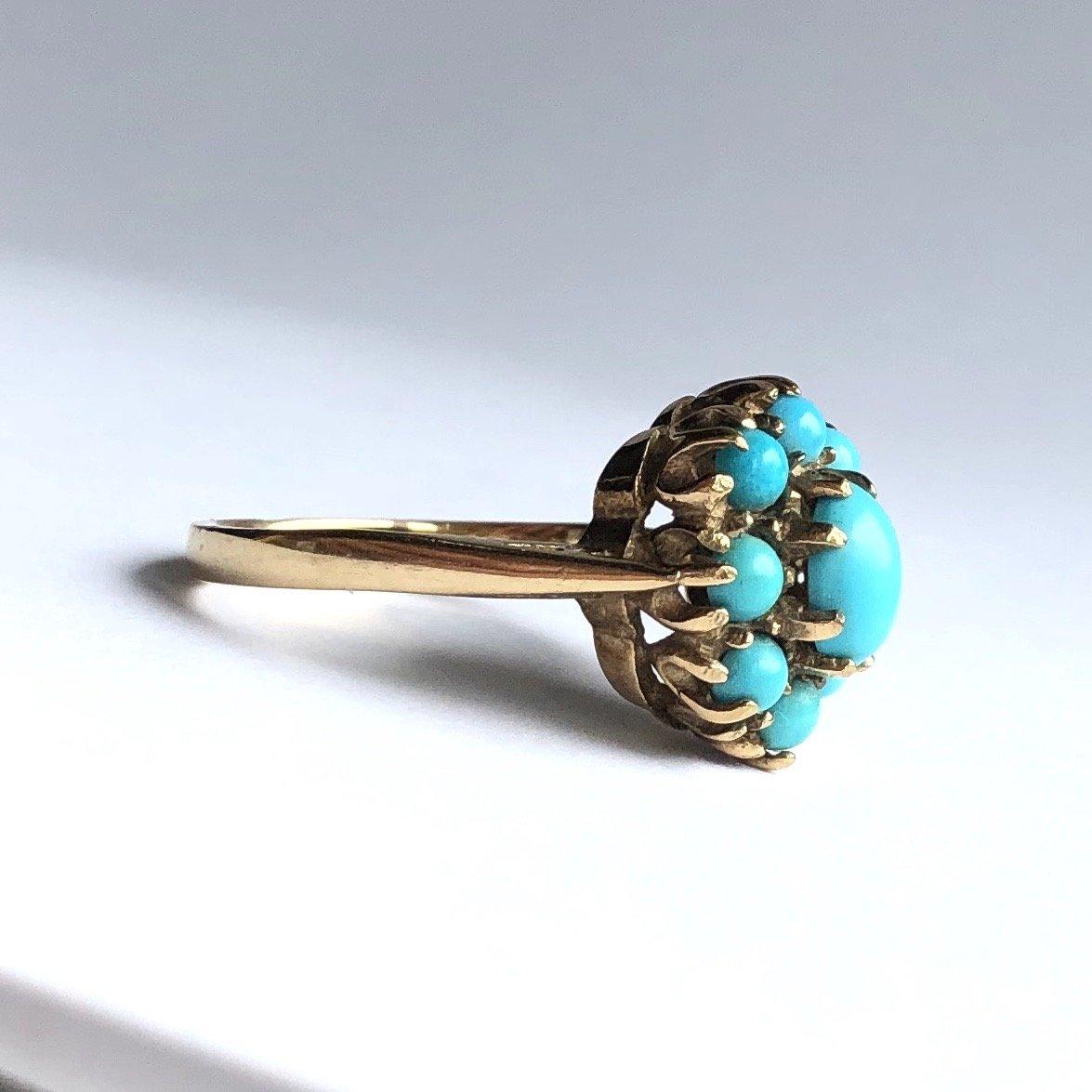The turquoise stones pop next to the yellow gold. The cluster sits high and the stones graduate in size starting with the smallest around the outside and the largest in the middle. 

Ring Size: O or 7 1/2 
Cluster Dimensions: 14x12mm 
Height From