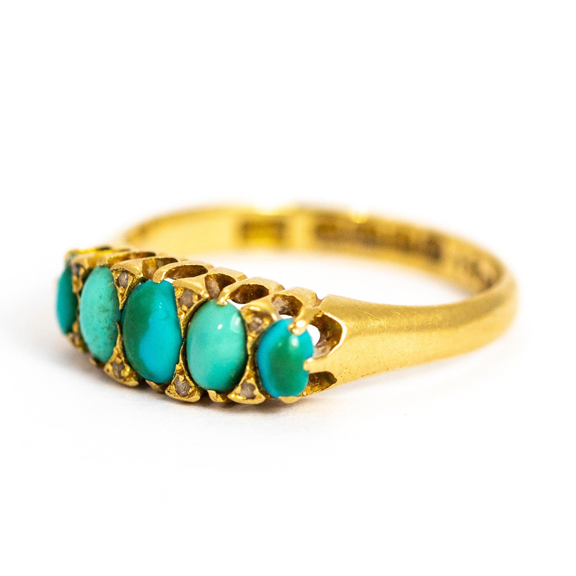 This wonderful turquoise five stone ring is modelled in 18ct gold and features eight small diamond points that sit between the oval turquoise stone cabochons. The band the stones sit ones quite chunky and very simple. Made in Birmingham, England.