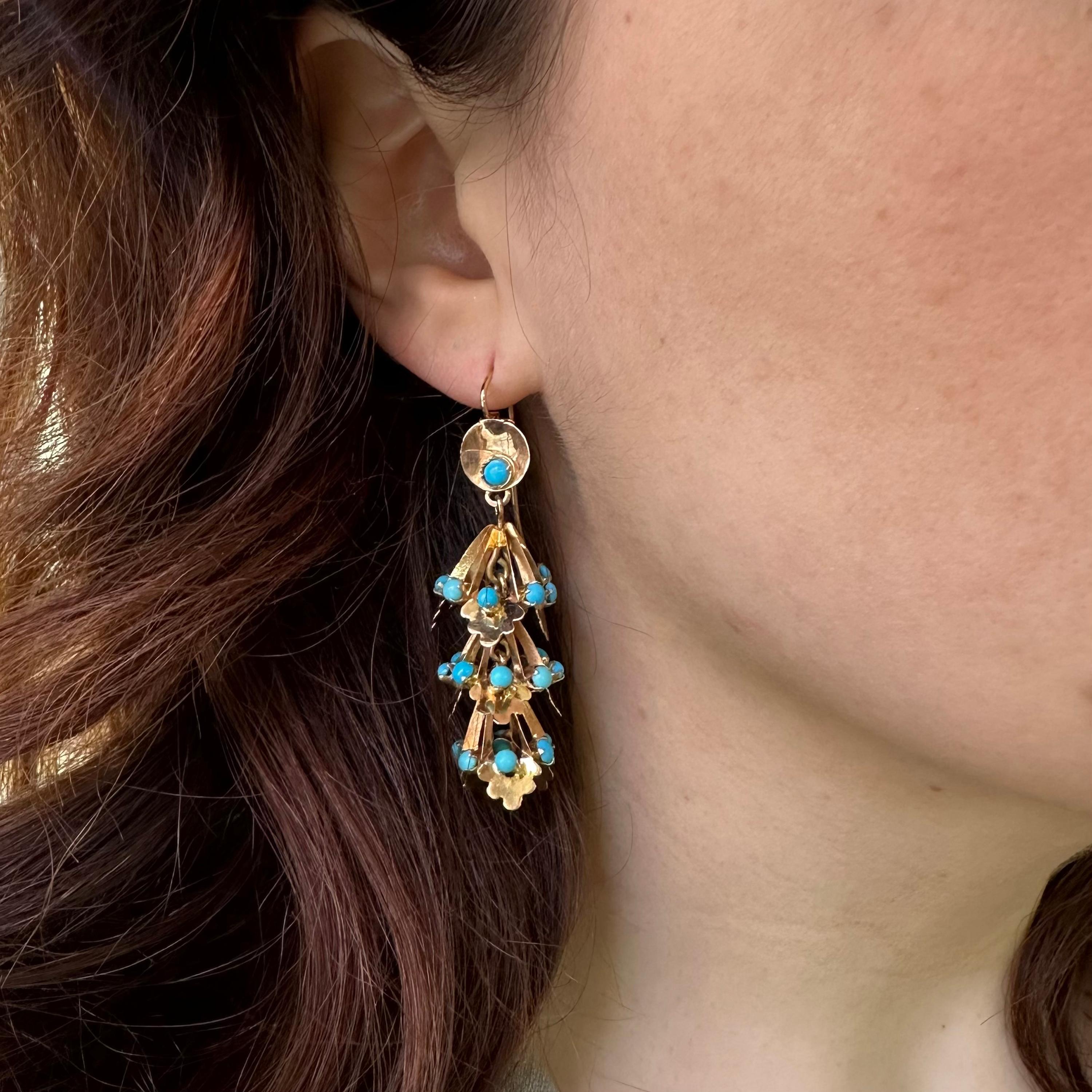 Ein Paar Vintage-Ohrringe aus Türkis und Gold, mit einer an Ohrdrähten hängenden Scheibe, an der drei goldene Etagen hängen, besetzt mit Cabochon-Türkisen, in Gold gefasst, um 1950.