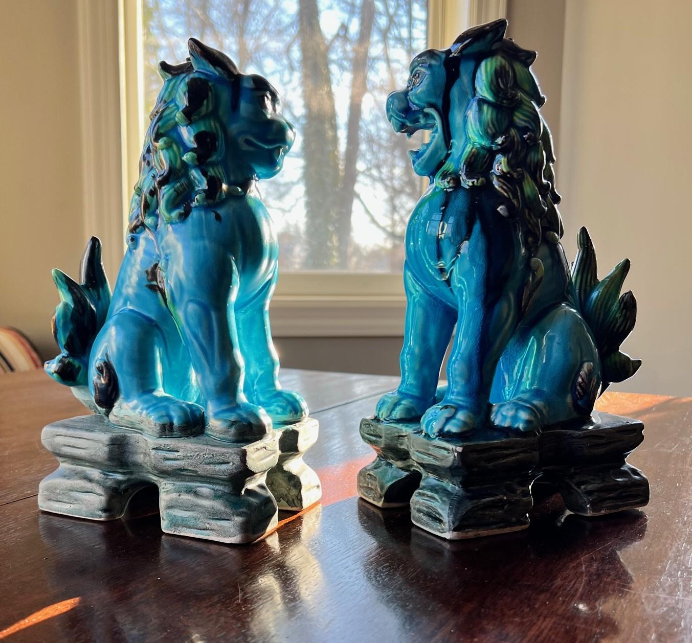 Paire de Komainu ou chiens-lions japonais du milieu du siècle dernier, en céramique avec une glaçure principalement vert turquoise mélangée à des verts, des bleus, des noirs et des bruns. La glaçure du Komainu mâle est plus brillante que celle de la