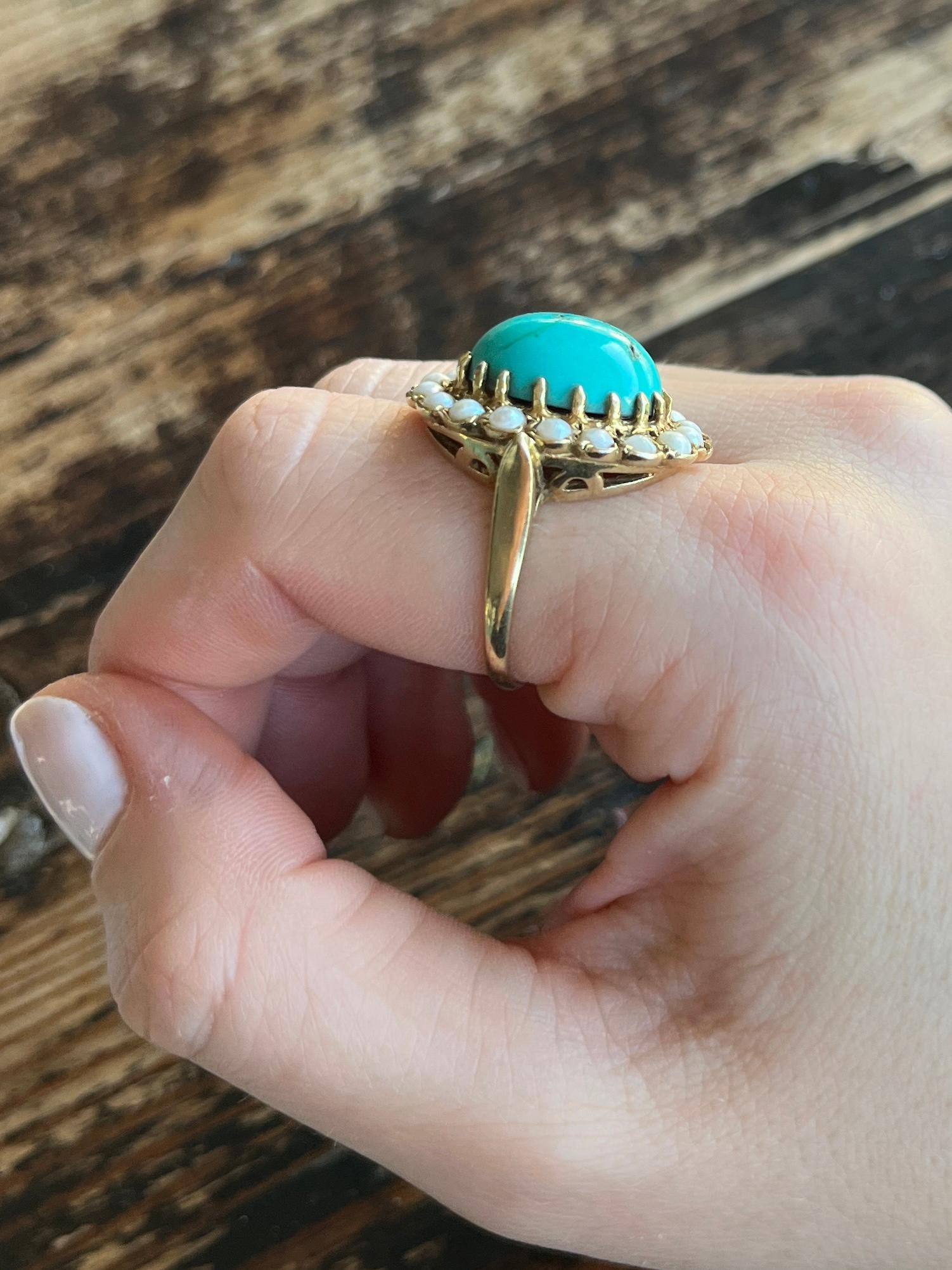 This glossy 9ct gold band holds a beautifully bright natural turquoise cabochon. This is surrounded by pearls.  

Ring Size:Q 1/2 or 8 1/2 
Face Diameters: 20x24mm

Weight: 8.5g