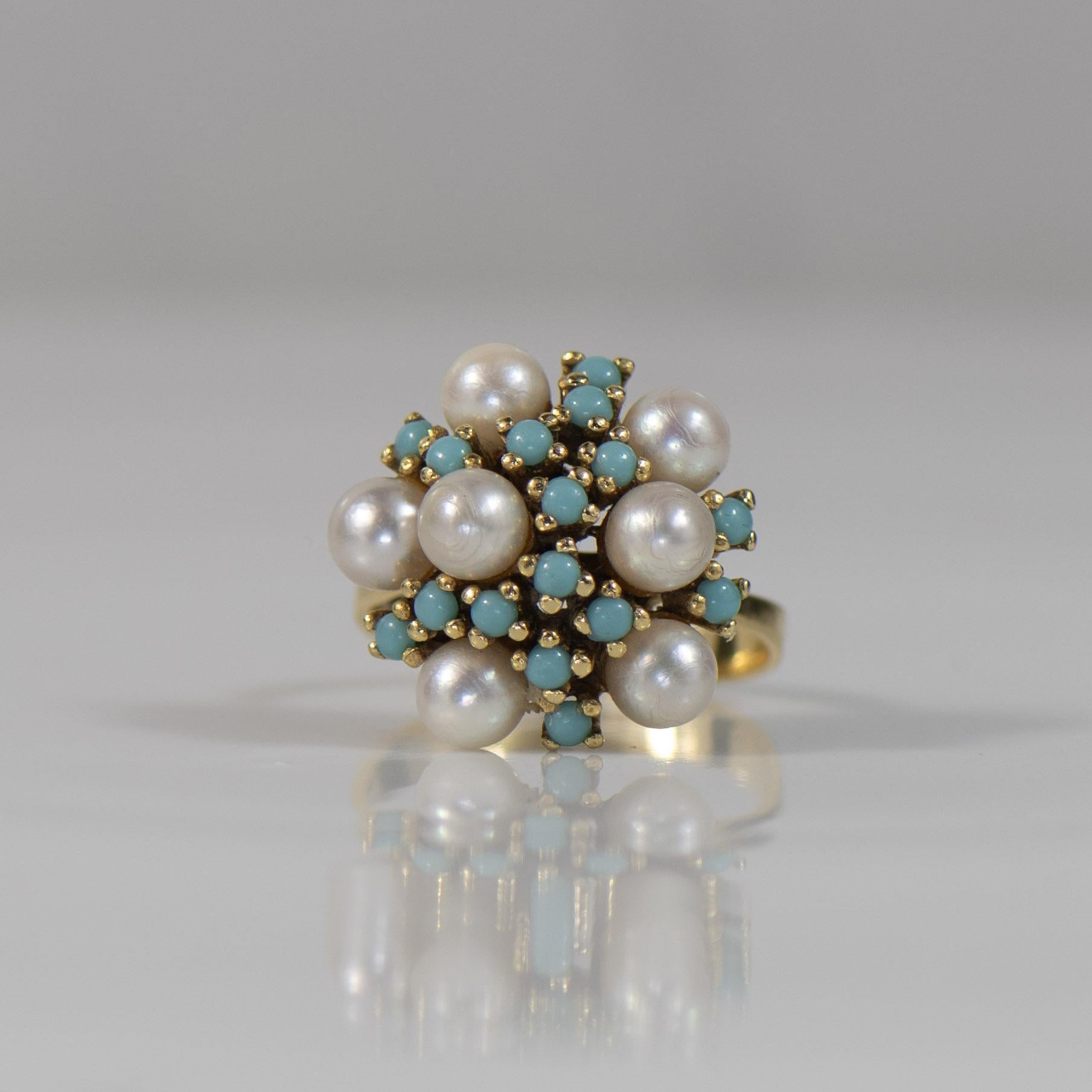 Transport yourself to a bygone era with this enchanting vintage Turquoise and Pearl Cluster Ring. The vibrant turquoise stones create a striking contrast against the lustrous pearls, forming a delicate cluster that evokes classic elegance. Set in a