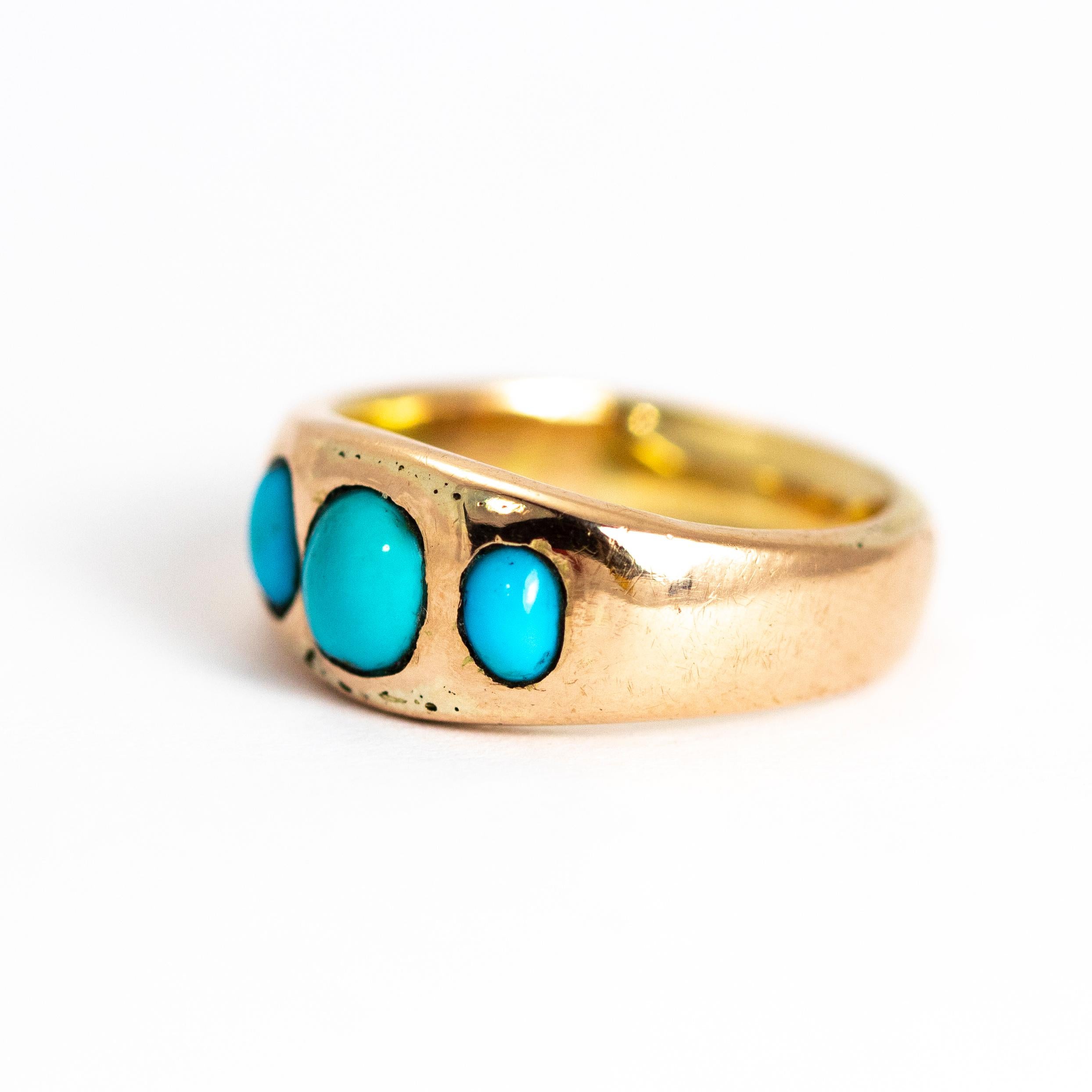 The pop of the bright turquoise next to the glossy gold band makes the perfect pairing. The centre circular stone is slightly larger than the two smaller oval stones. The way the stones are set into this gold band give the ring a sort of lovely