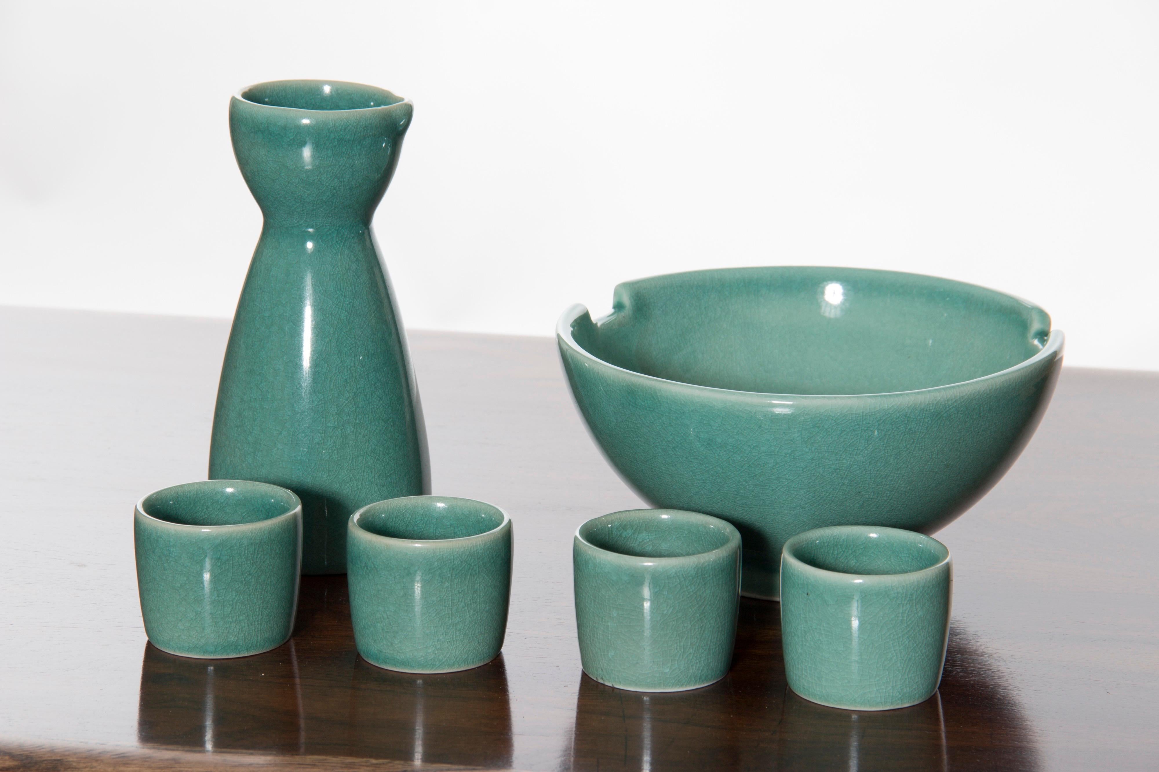 Vintage Turquoise ceramic sake set in perfect condition. Set includes one sake decanter with a tapered neck and rounded body called a tokkuri. The tokkuri is used at the table when the sake is transferred from the bottle. Set includes also four
