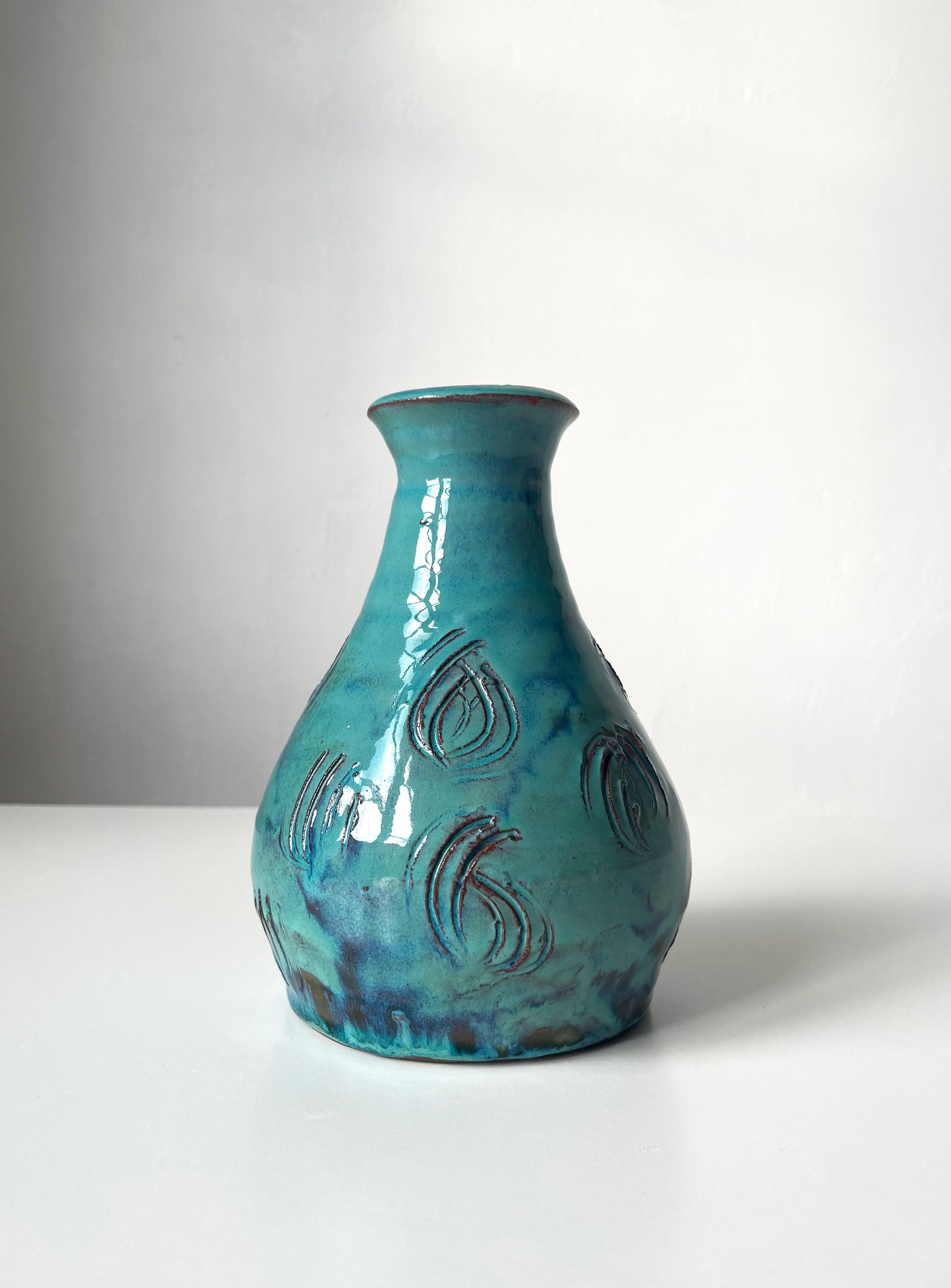 Scandinavian modern vintage turquoise and black handmade ceramic vase. Incised lined pattern in double semicircles decorating the item. Thick running glaze in turquoise, blue, aqua and black colors cover the soft shaped pottery. Great vintage