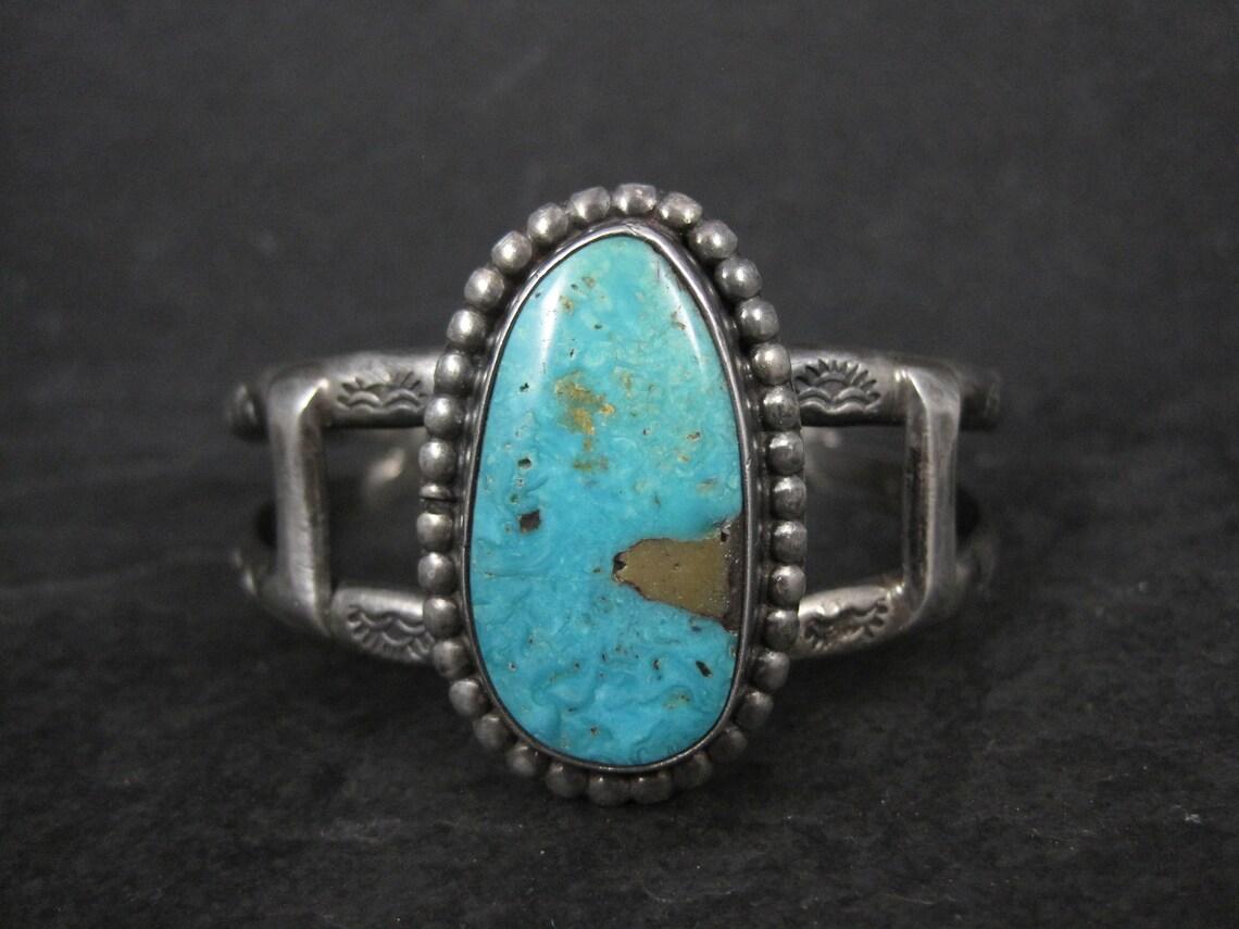 This gorgeous, vintage, Southwestern cuff bracelet is sterling silver.
It features a 29x16mm natural turquoise gemstone.

The face of this cuff measures 1 3/8 inches at its widest point.
It has an inner circumference of 6 inches including the 1 1/8