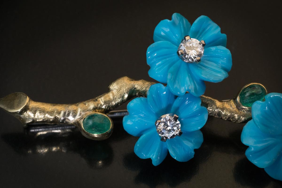 Made in Vienna, Austria in the 1950s.

The vintage 18K yellow gold brooch is designed as a blooming branch with finely carved turquoise flowers of a vivid blue color accented by old mine and modern brilliant cut diamonds, and cabochon cut