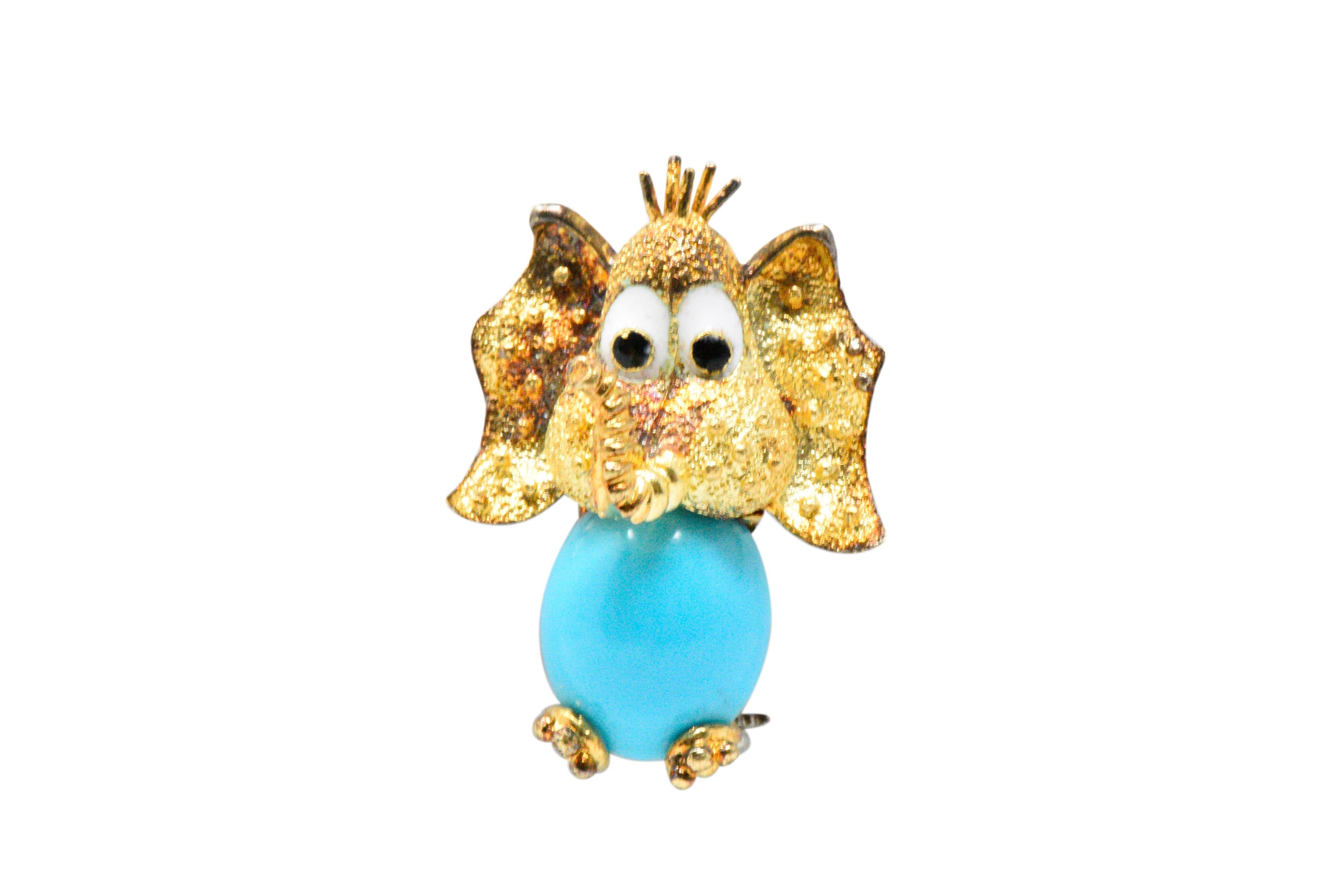 Designed as a comical elephant with a oval cabochon turquoise body, turquoise measuring approximately 12.0 x 10.0 mm, bright even turquoise blue color, with very good polish and luster

Big black and white enamel eyes

Textured gold head, ears and