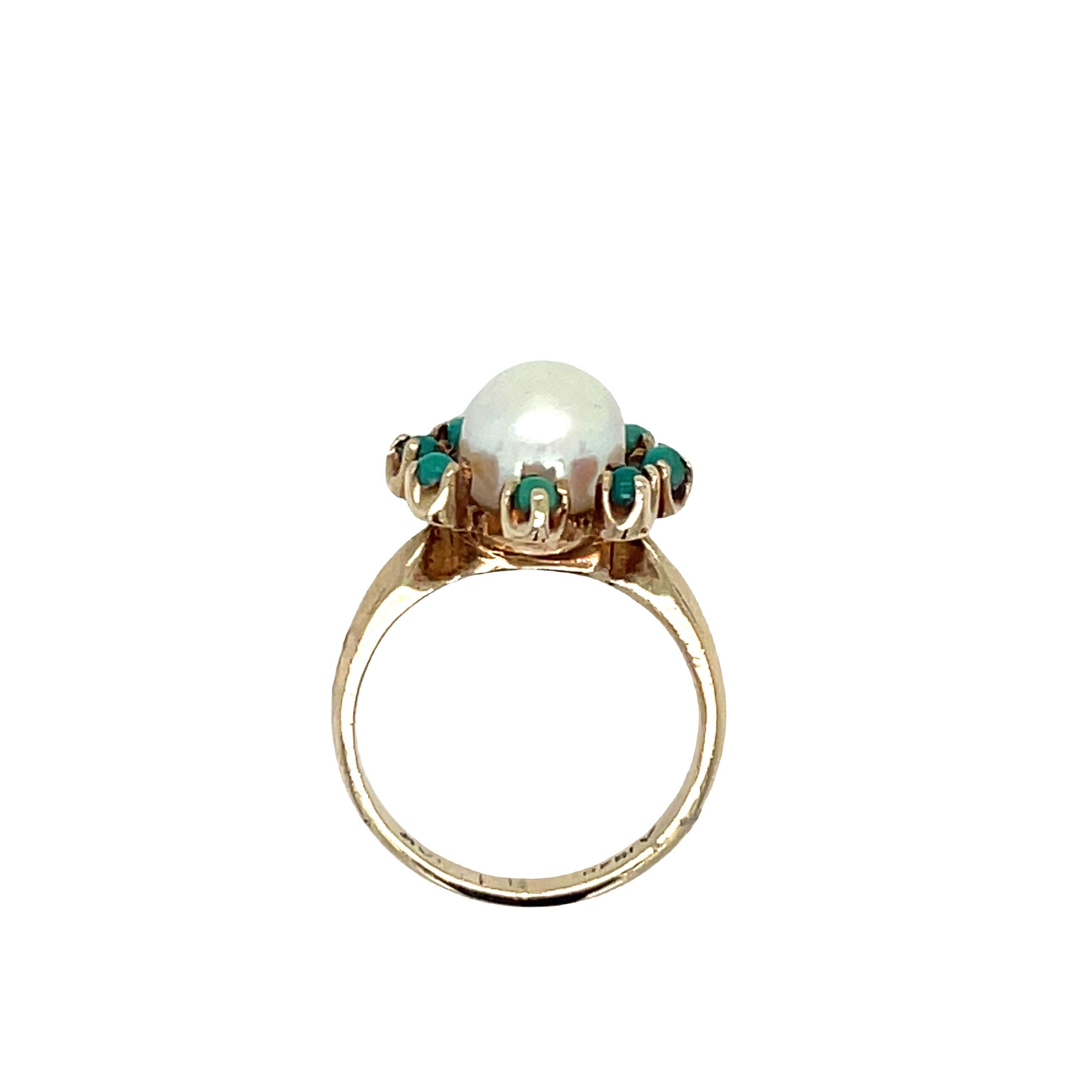 Beautiful antique ring crafted in 10k yellow gold. This lovely piece showcases a center pearl surrounded by eight small round turquoises in a cluster-style setting.
The vintage ring features a cultured pearl measuring 5.8 mm, elegantly encircled by