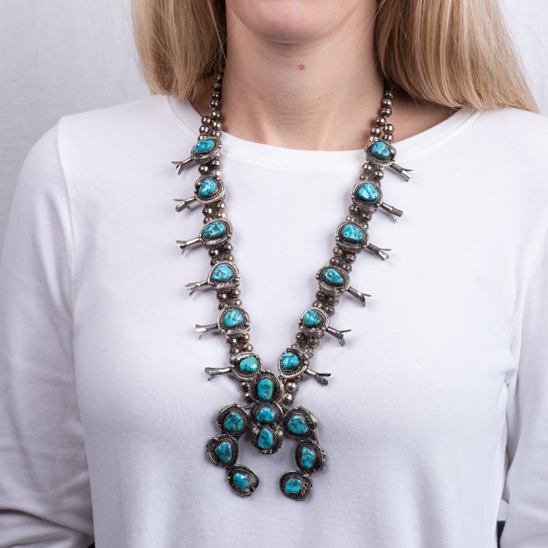 This beautifully made vintage necklace features natural Kingman mine turquoise in Arizona. The stones and squash blossom are set in silver on a double beaded strand. This piece was made in the 1970's.
Measurements: Approximately 15