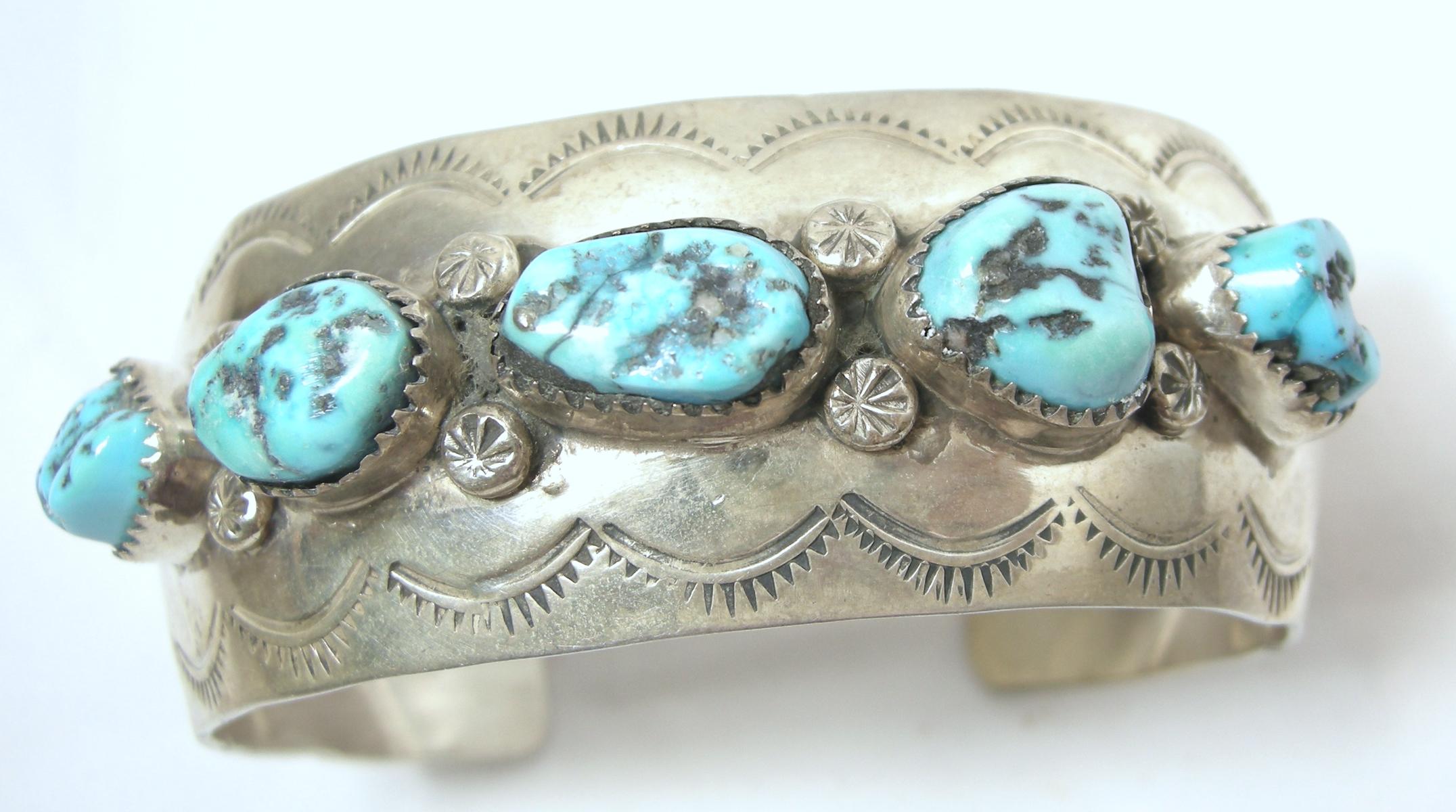 This vintage sterling silver cuff bracelet has turquoise nuggets in the front. In excellent condition, this cuff bracelet measures 7” x 1”.