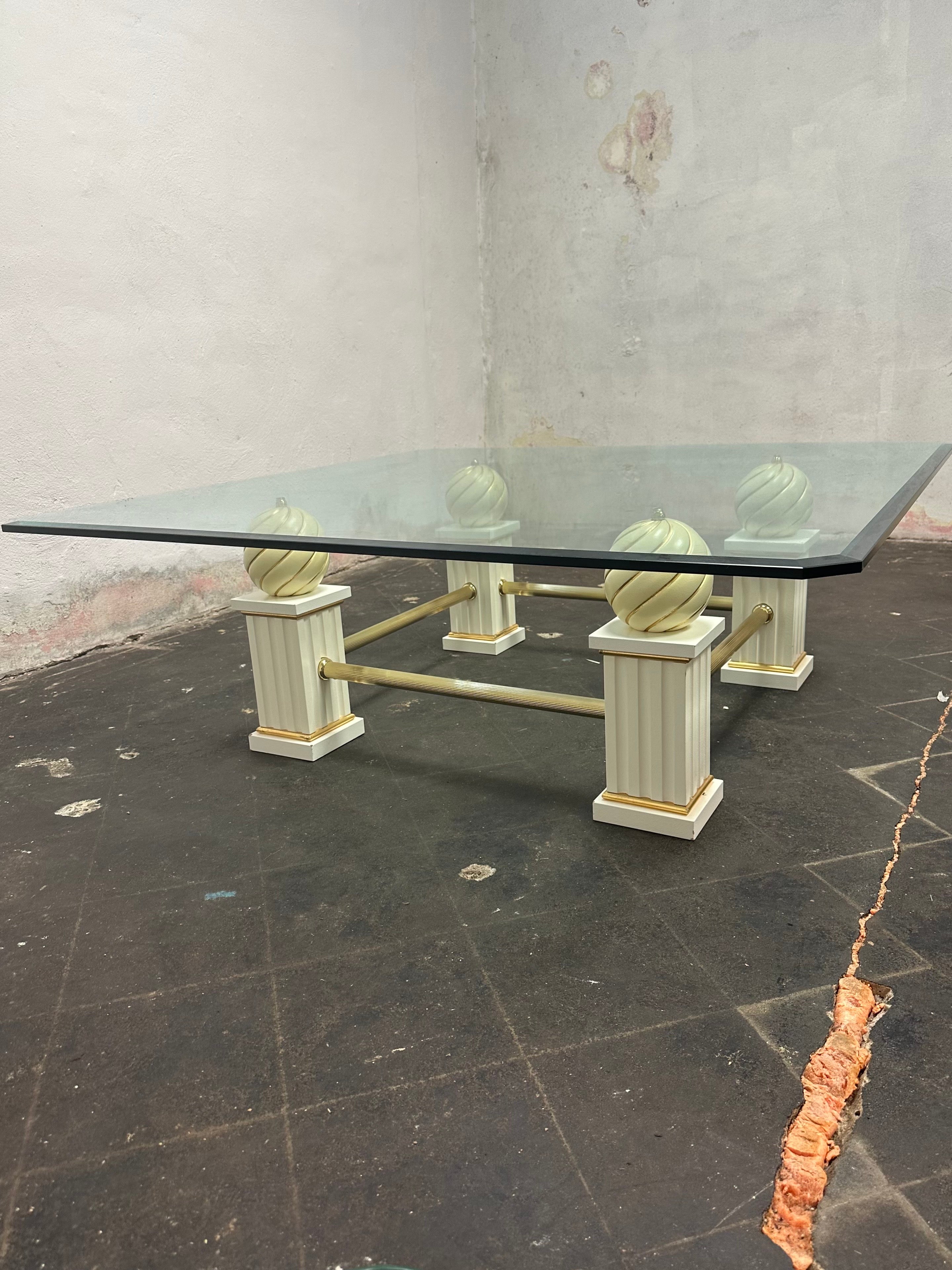 Il tavolino quadrato Arcade del produttore italiano Turri. Struttura in legno massiccio, decorata a mano, finitura in poliestere lucido color avorio/oro. Ci sono parti in metallo realizzate in ottone. Profili decorativi in legno con decorazione in