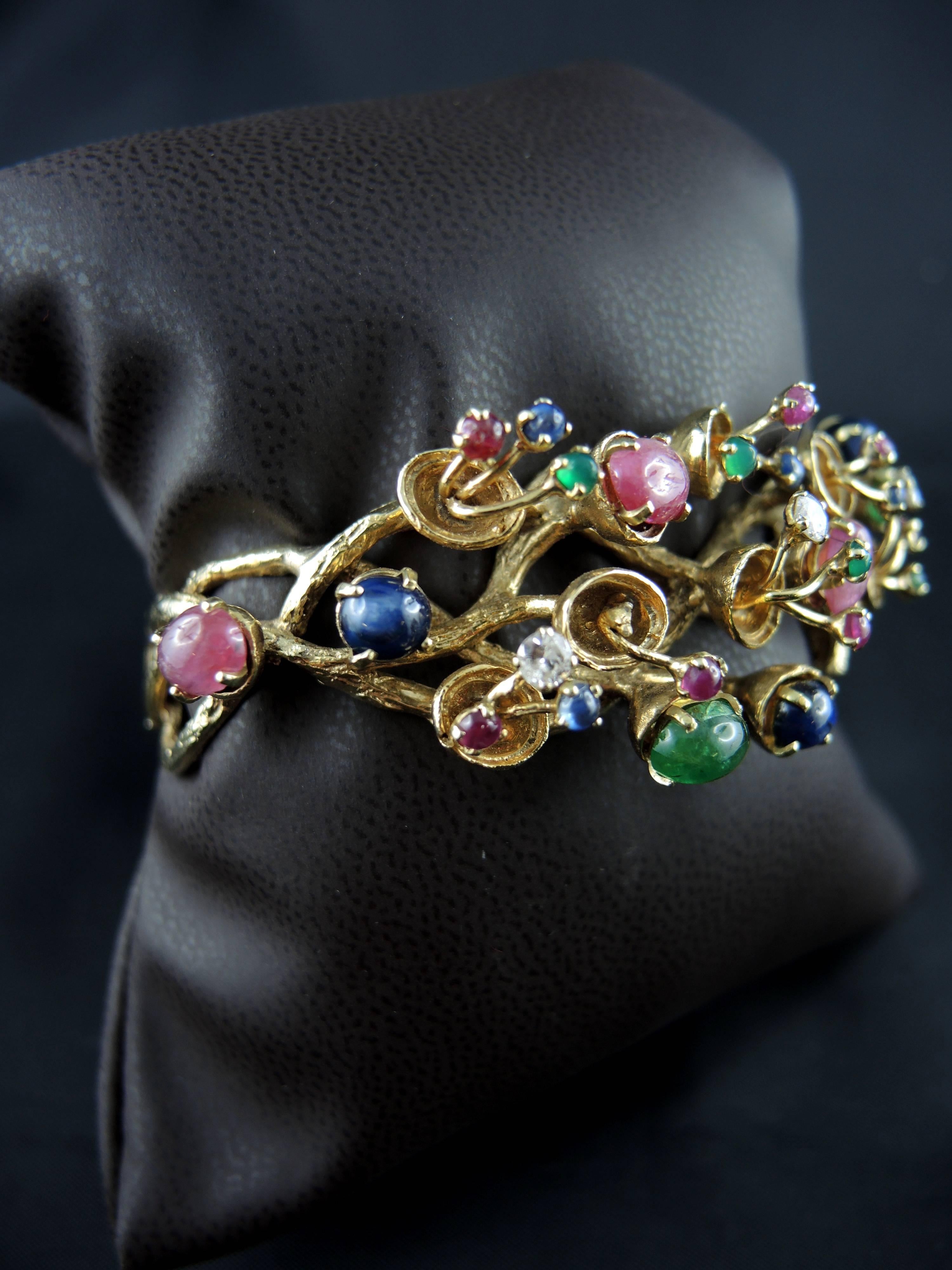 Impressive 14kt yellow gold Tutti Frutti bracelet (quality mark: scallop) set with rubies, sapphires, emeralds, and diamonds.

Circa 1970.

Weight: 45.10 g

State : very little scratches on the gold parts, very light abrasion of the stones, visible