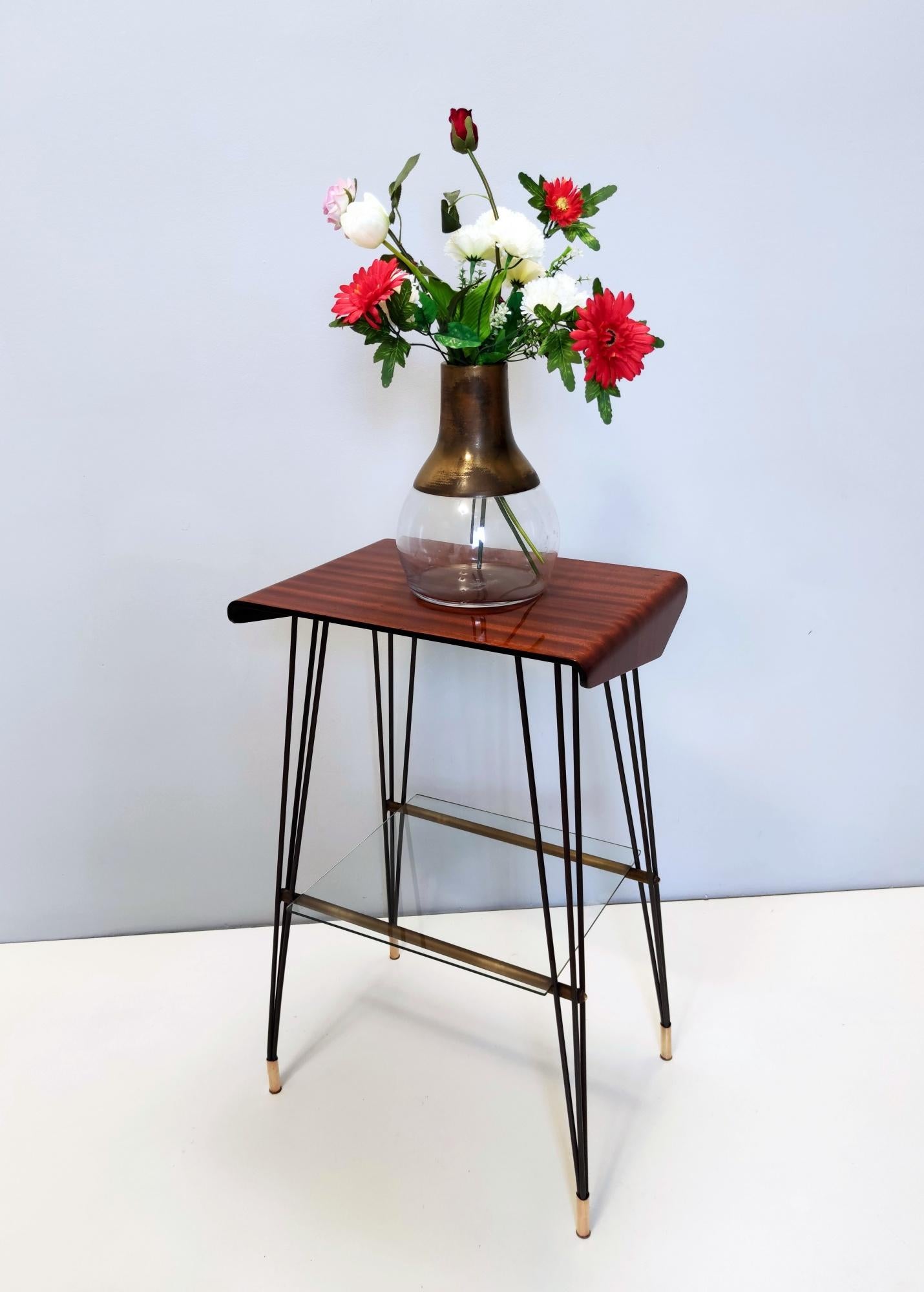 Made in Italy, 1960s. 
This side table features a varnished iron and brass frame with a multi-layered ebonized beech top and a glass shelf. 
It is a vintage piece, therefore it might show slight traces of use, but it can be considered as in very