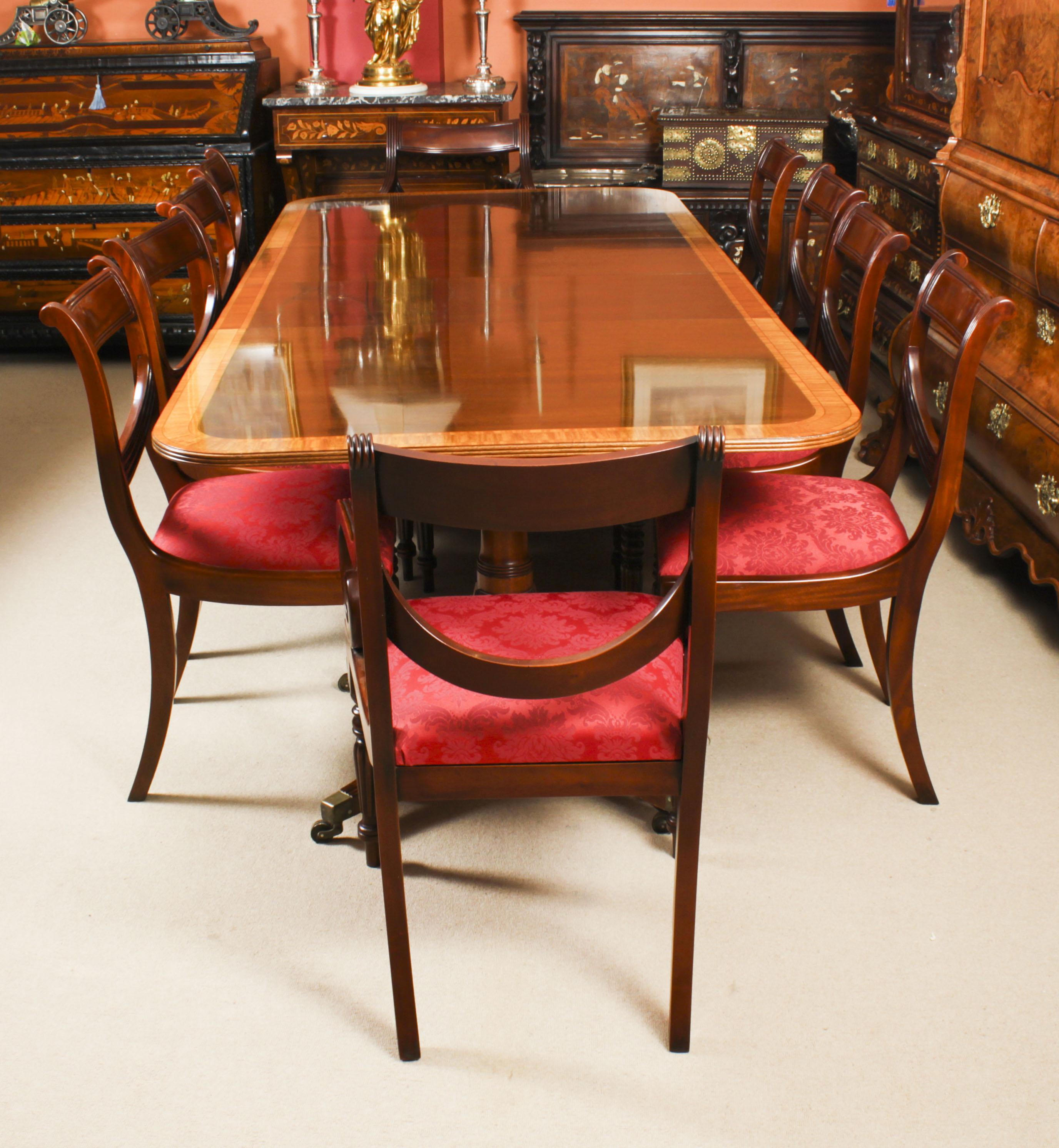 This is fabulous Vintage Regency Revival dining table by the master cabinet maker William Tillman Circa 1980 in date with a set of ten Regency Revival swag back dining chairs.

The table is made of stunning solid flame mahogany with satinwood