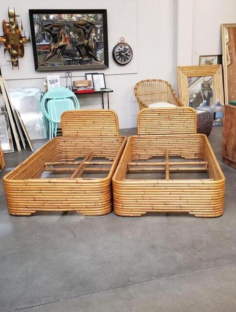 This twin-size bed frame pair was built by Seven Seas Rattan Company (1938 to 2011) in the 1950s. Each bedframe features a stacked rattan base with a stacked rattan headboard. and takes a single-size US mattress. 
 
It is modeled after the smaller